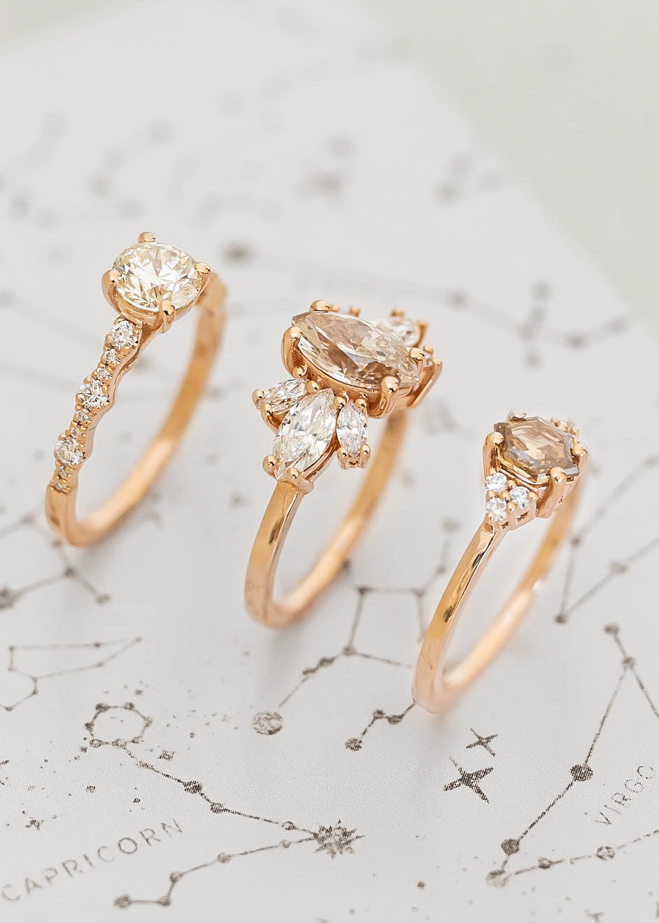 three rings set up on a background of astrological data, representing different birthstones 