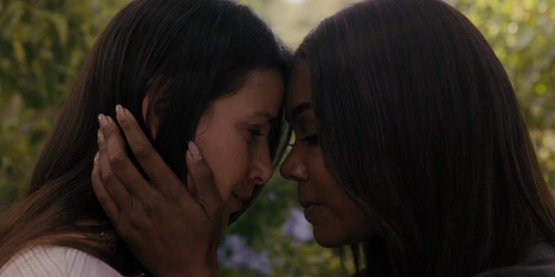 Truth Be Told: Eve cradles Alicia's face between her hands. Their foreheads are pressed against each other and they look like they're on the verge of a kiss.
