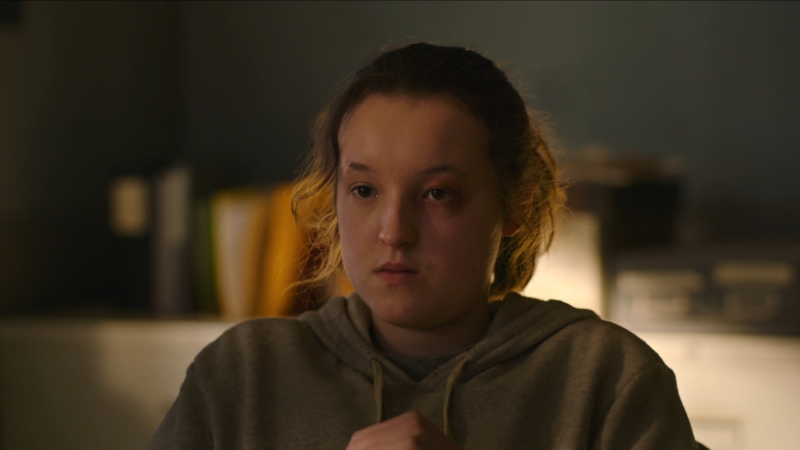 Ellie scowls in the captain's office with a black eye.