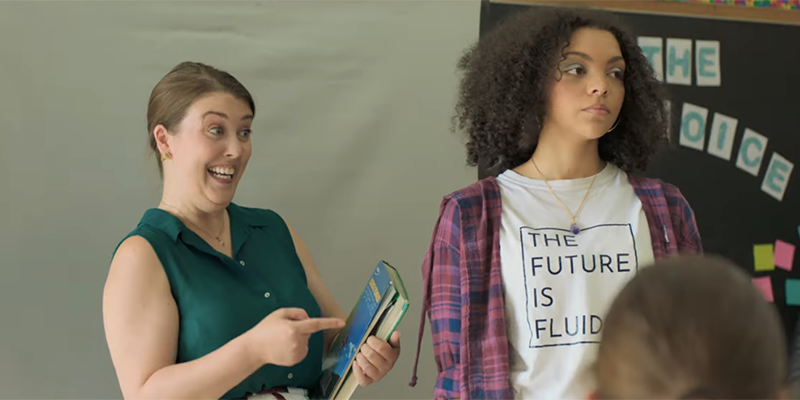 Sydni stands in front of the class waring a shirt that says "The Future Is Fluid."