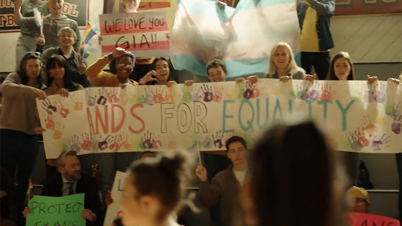 On Quantum Leap, a group of fans hold a sign that says "hands for equality" 