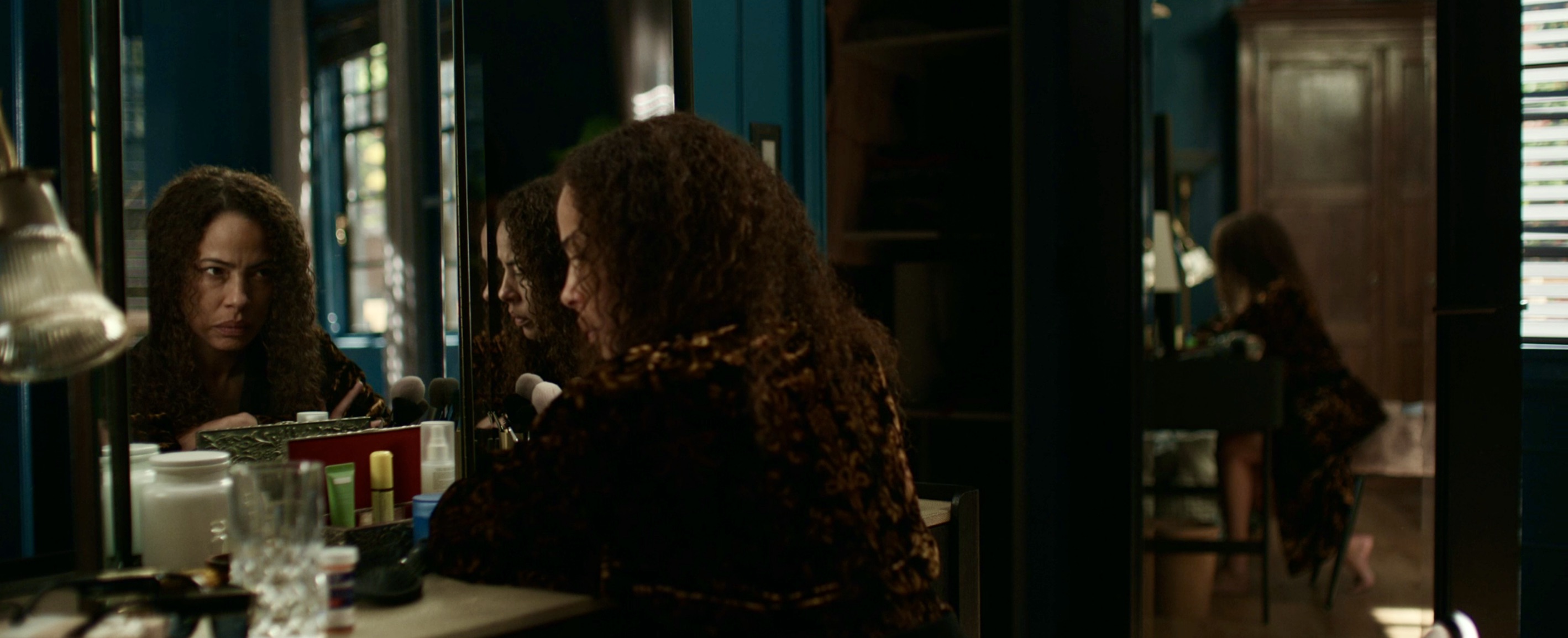 Taissa's reflection glares at her in the mirror