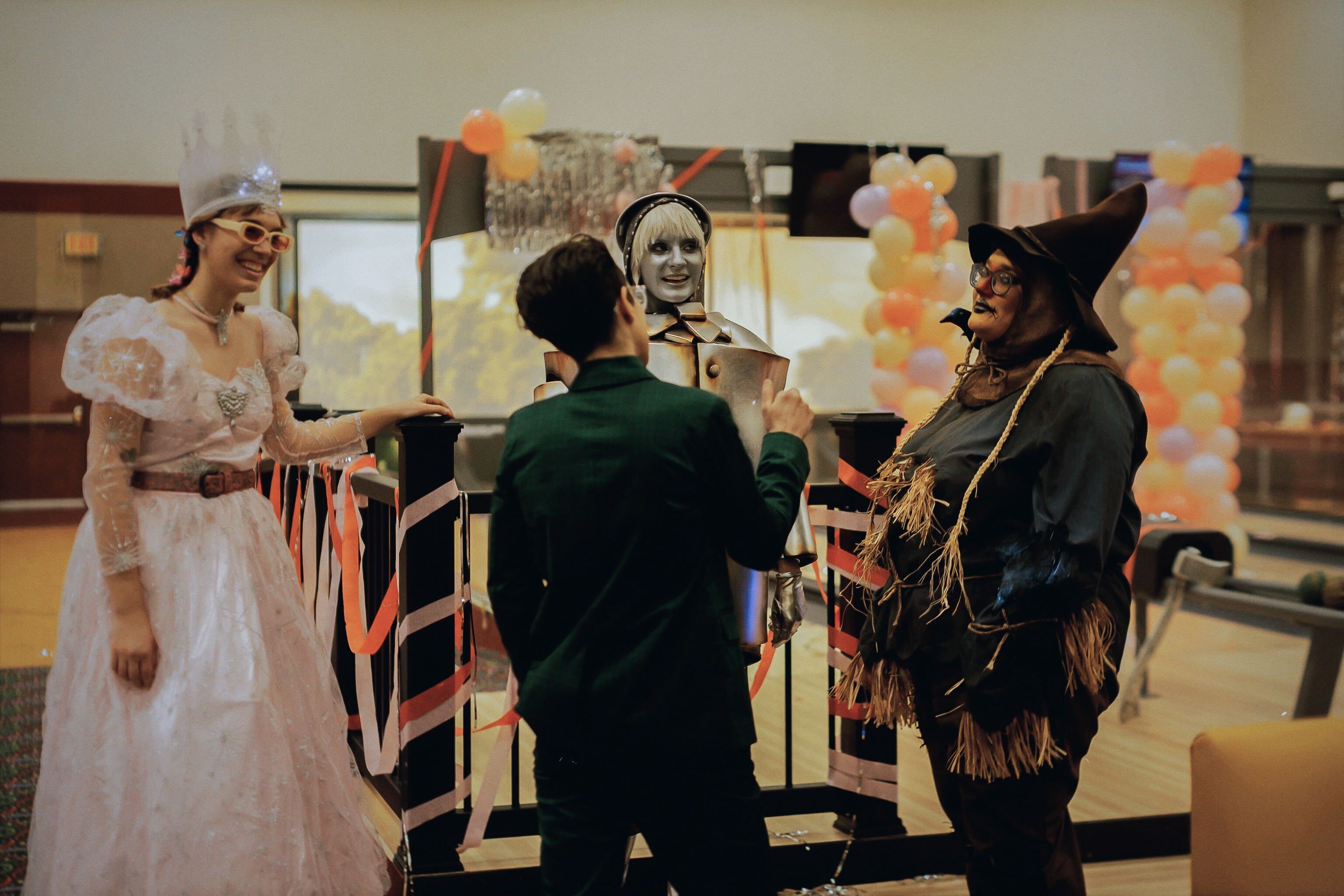 a group of people dressed as Wizard Of Oz characters for the "Night Shift" video, including Carmen Maria Machado as a scarecrow