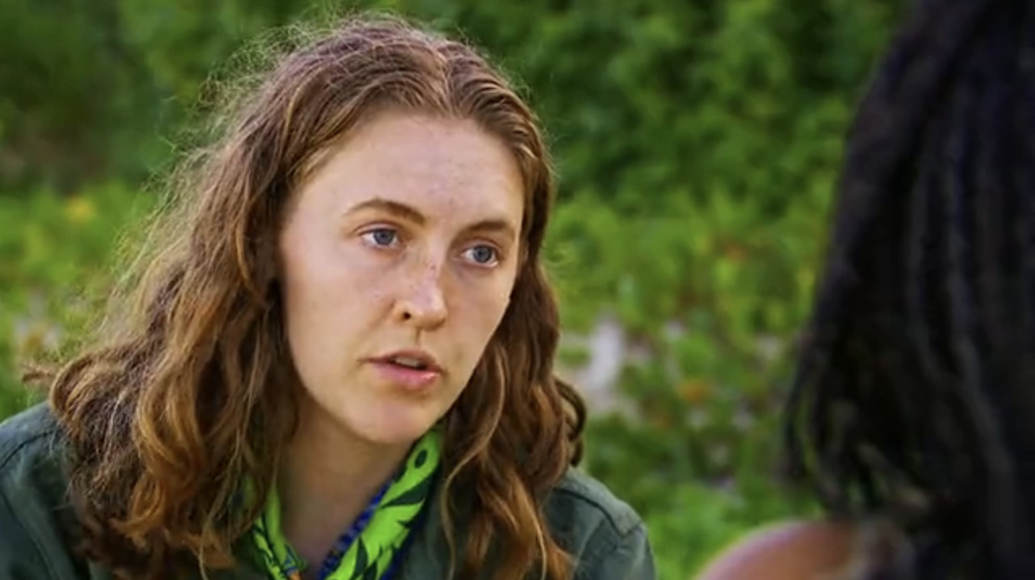 Survivor season 44 contestant Frannie Marin looks at an unseen listener, appearing very stern and serious