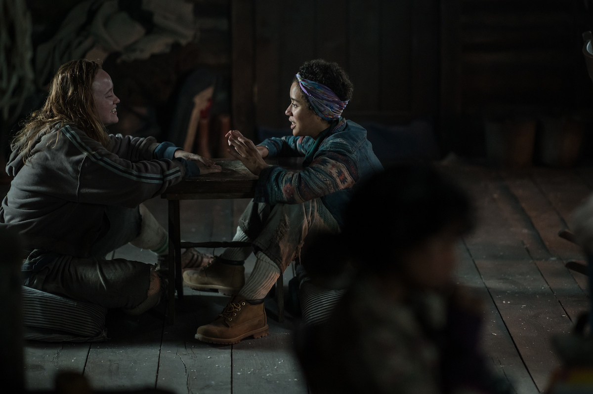 Yellowjackets (L-R): Liv Hewson as Teen Van and Jasmin Savoy Brown as Teen Taissa in YELLOWJACKETS Season 2 sitting on the floor holding their hands up. Photo Credit: Kailey Schwerman/SHOWTIME.