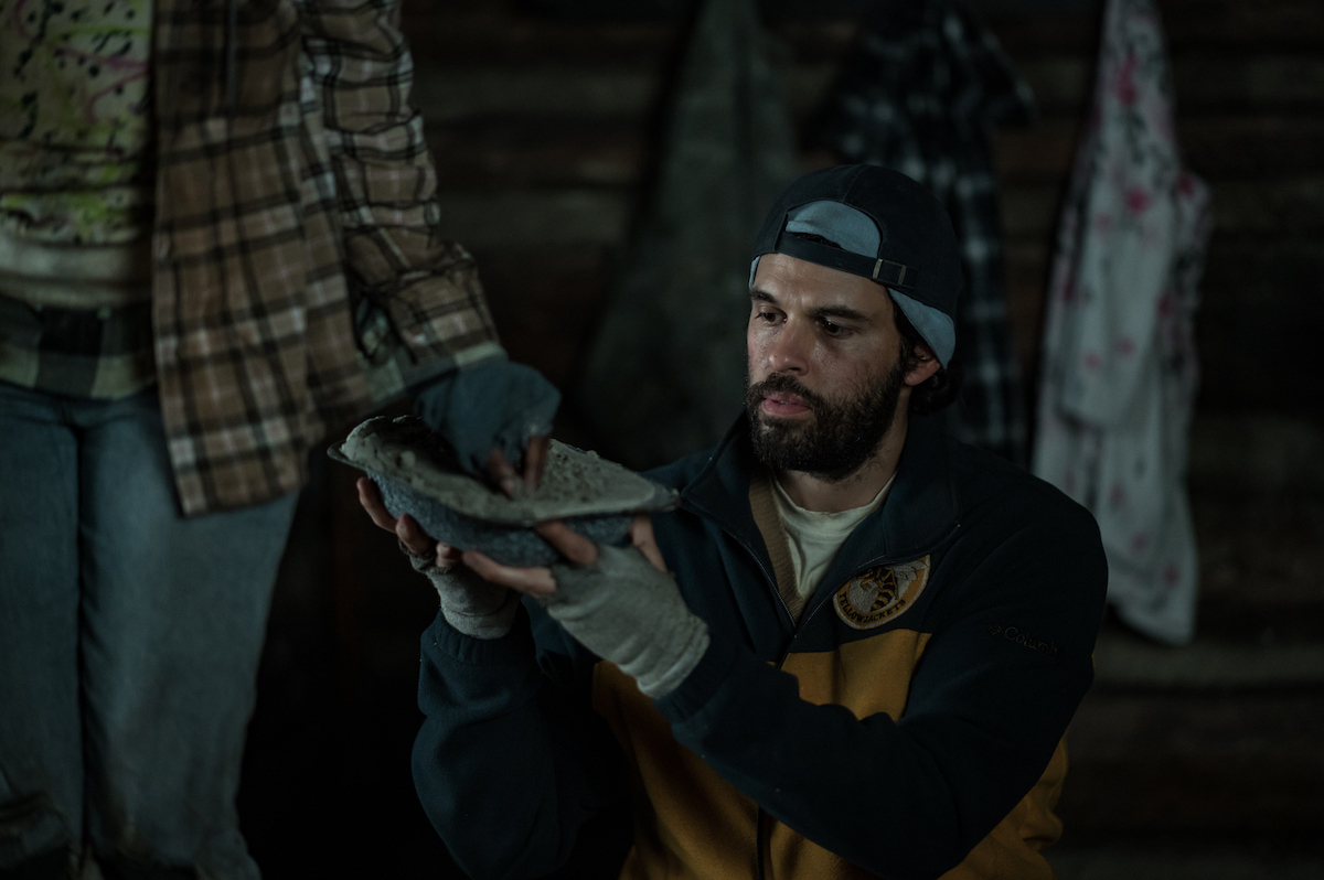 Yellowjackets Steven Krueger as Ben Scott in YELLOWJACKETS Season 2 holds up a boot. Photo Credit: Kailey Schwerman/SHOWTIME.