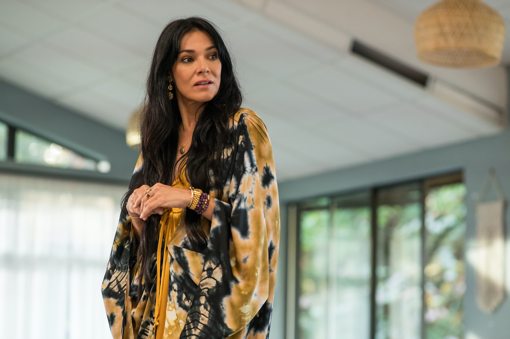 Yellowjackets - Season 2 Simone Kessell as Lottie in YELLOWJACKETS Season 2 in a floral robe stands in sunlight. Photo Credit: Kailey Schwerman/SHOWTIME.