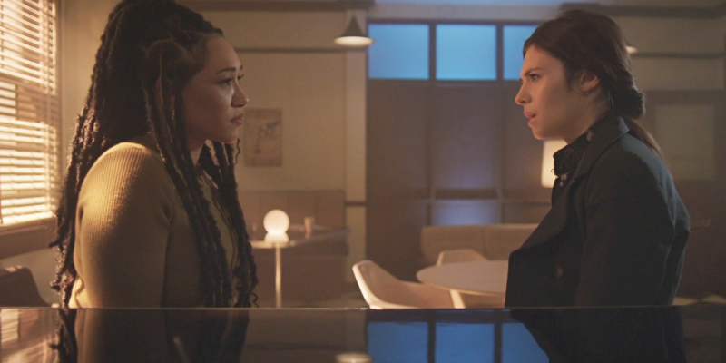 Iris and Nia talk in a dream office