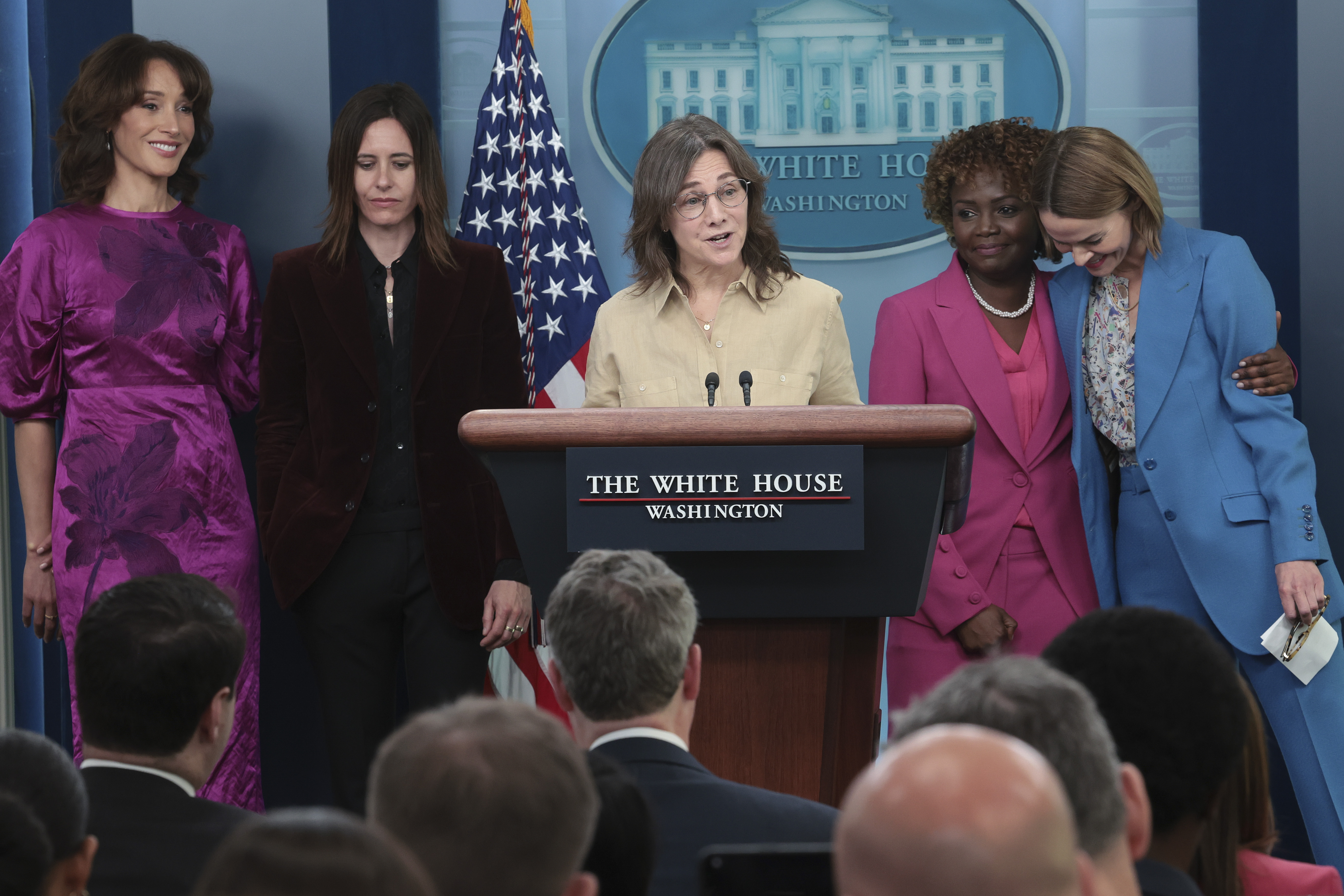 White House press secretary Karine Jean-Pierre (2nd R) embraces actress Leisha Hailey (R) as the creator of the show "The L Word", Ilene Chaiken, (C) delivers remarks during the daily briefing at the White House with other members of the show's cast April 25, 2023 in Washington, DC. The cast of the show appeared at the briefing to mark Lesbian Visibility Week. Also pictured (L-R) are actresses Jennifer Beals, and Katherine Moennig.