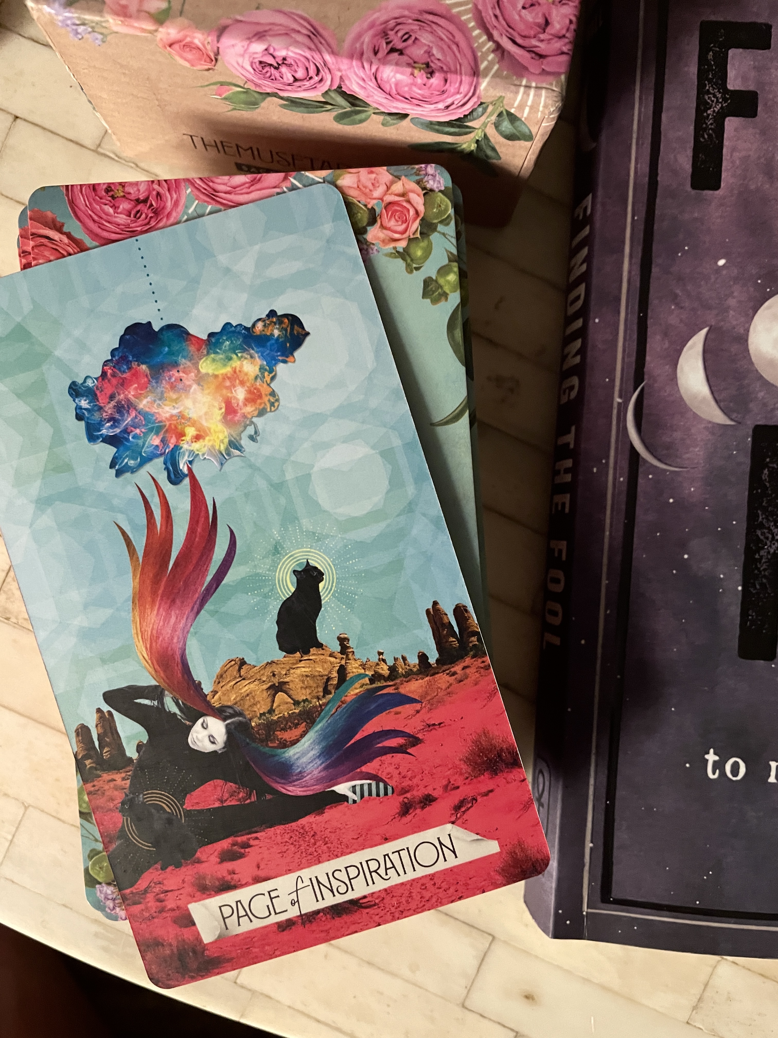 here Meg drew the page of inspiration. it has a feminine person with rainbowy hair in a desert environment with a black cat behind her. above is a rainbow cloud.