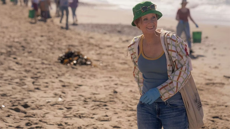 Miranda in a green bucket hat on the beach.