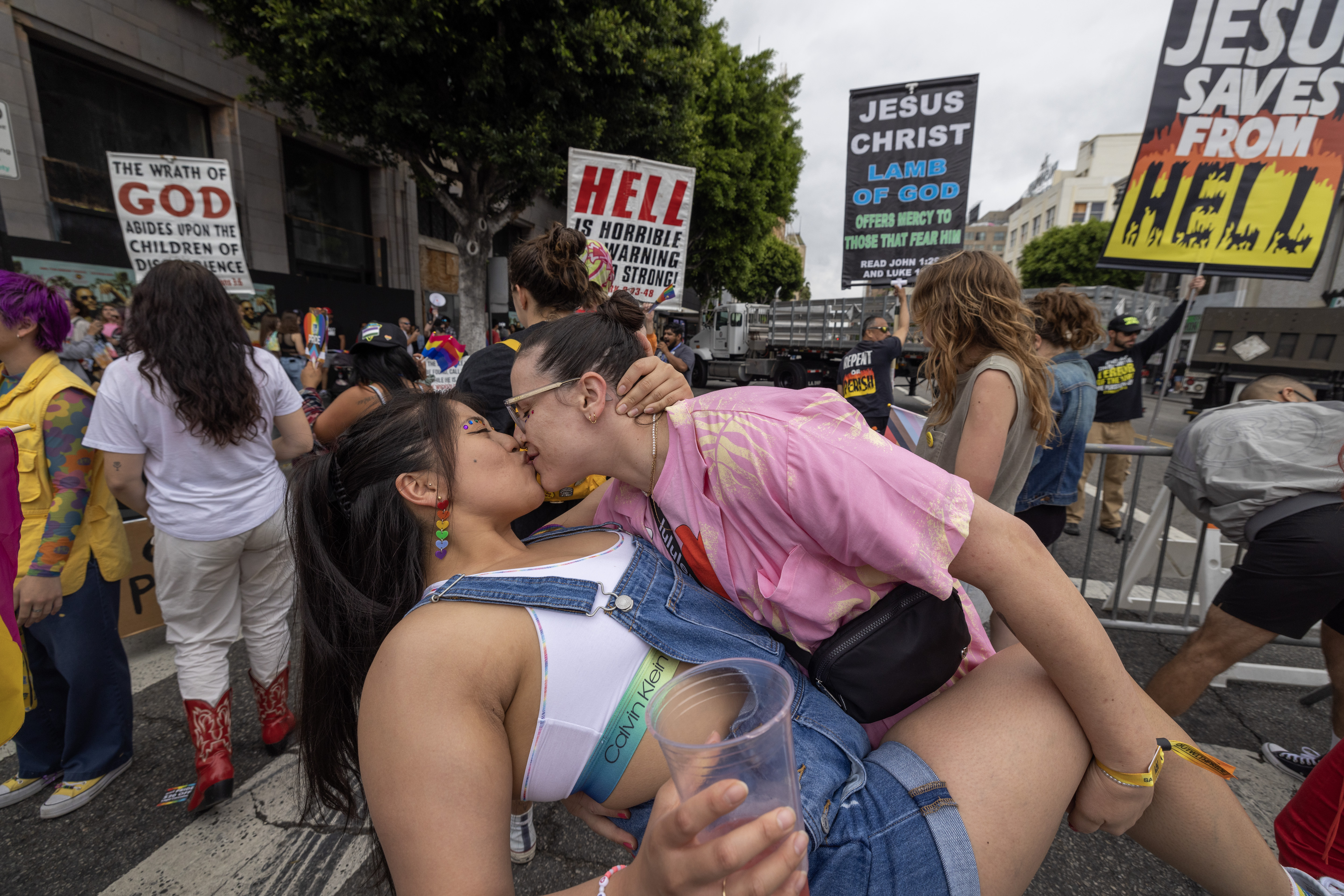 LOS ANGELES, CALIFORNIA - JUNE 11: People kiss in reaction to confrontational Evangelical Christians condemning the annual LA Pride Parade on June 11, 2023 in the Hollywood section of Los Angeles, California. The LA Pride Parade is one of the largest and oldest pride parades in the nation having begun one year after the 1969 'Stonewall Uprising' protest to a violent raid by police on gay patrons at the Stonewall Inn in New York City. The Gay Liberation Front responded by helping to organize gay parades in Los Angeles, San Francisco and New York City on that anniversary. Opposition to transexual rights and drag shows are currently major issues in Conservative politics. (Photo by David McNew/Getty Images)