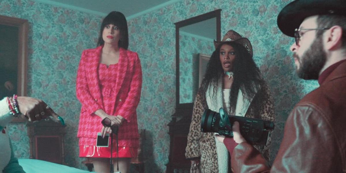 Living for the Dead: Roz and Juju look shocked as Ken films a woman talking about a ghost. (We only see part of his face and the woman's hand)