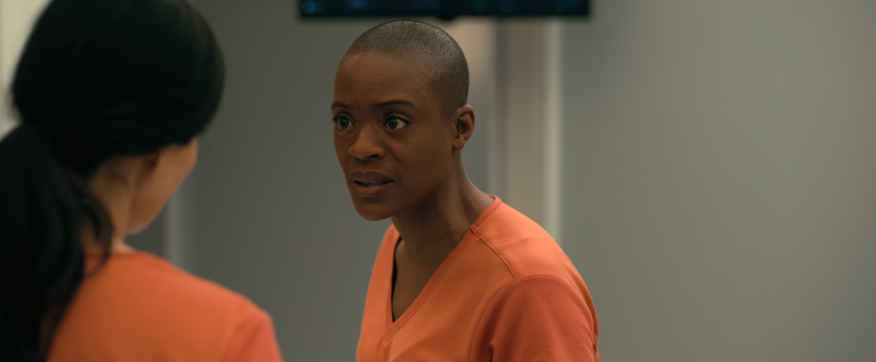 Alessandra and Vic in the lab, wearing orange scrubs