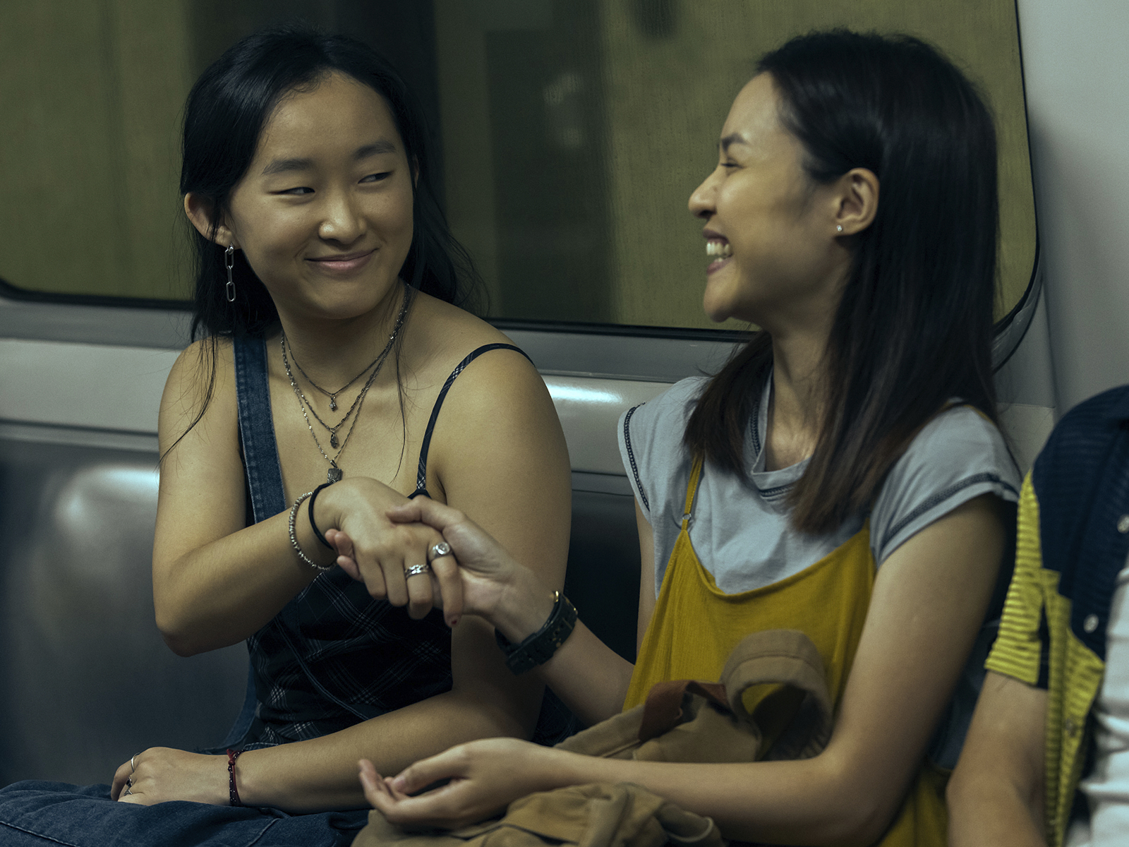 two girls on a subway train laughing in "Expats" on prime video