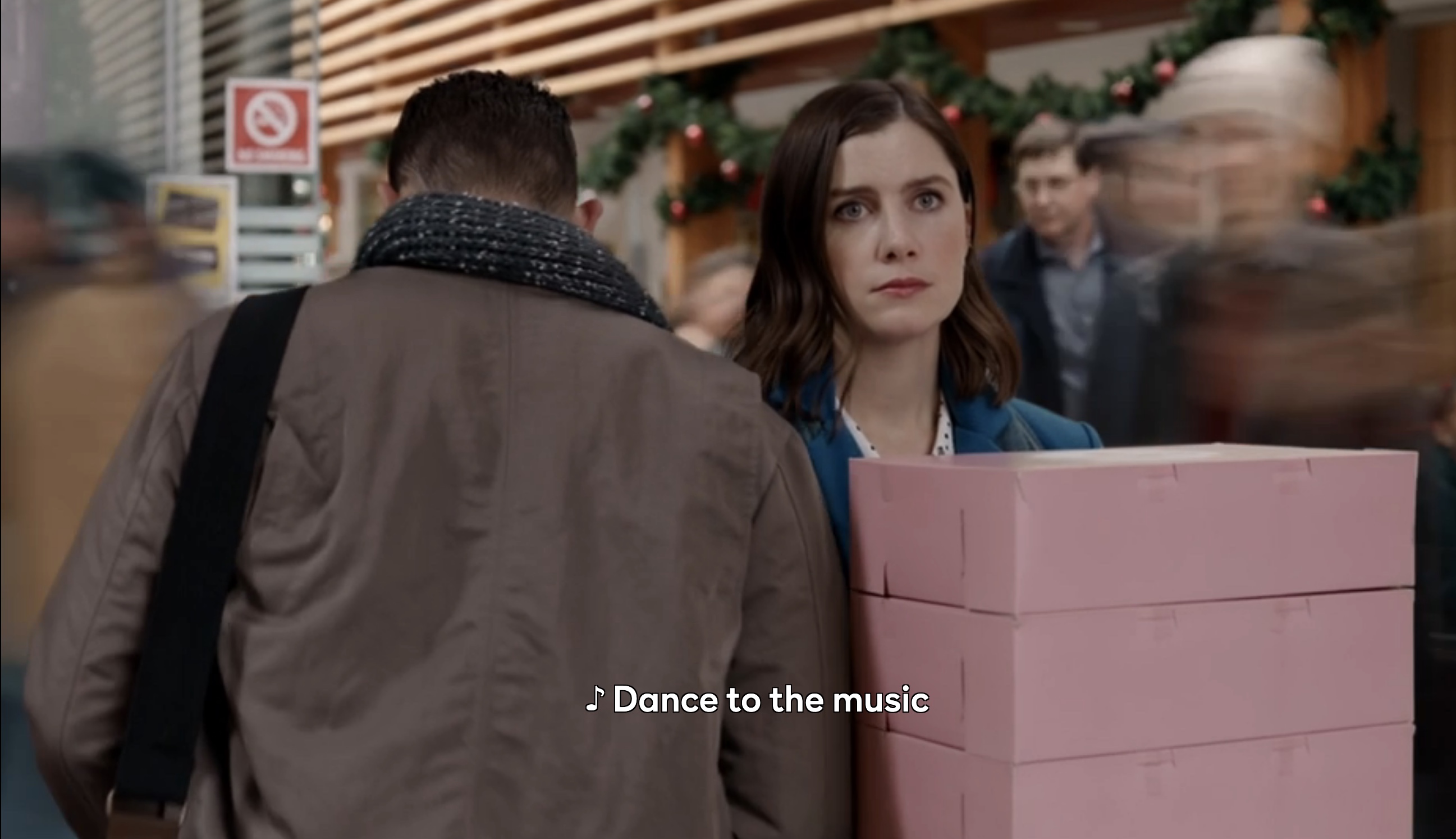 "Dance to the music" while she stands sad with boxes of donuts