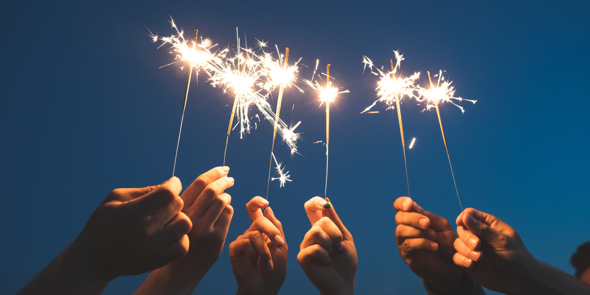 a bunch of people holding sparklers