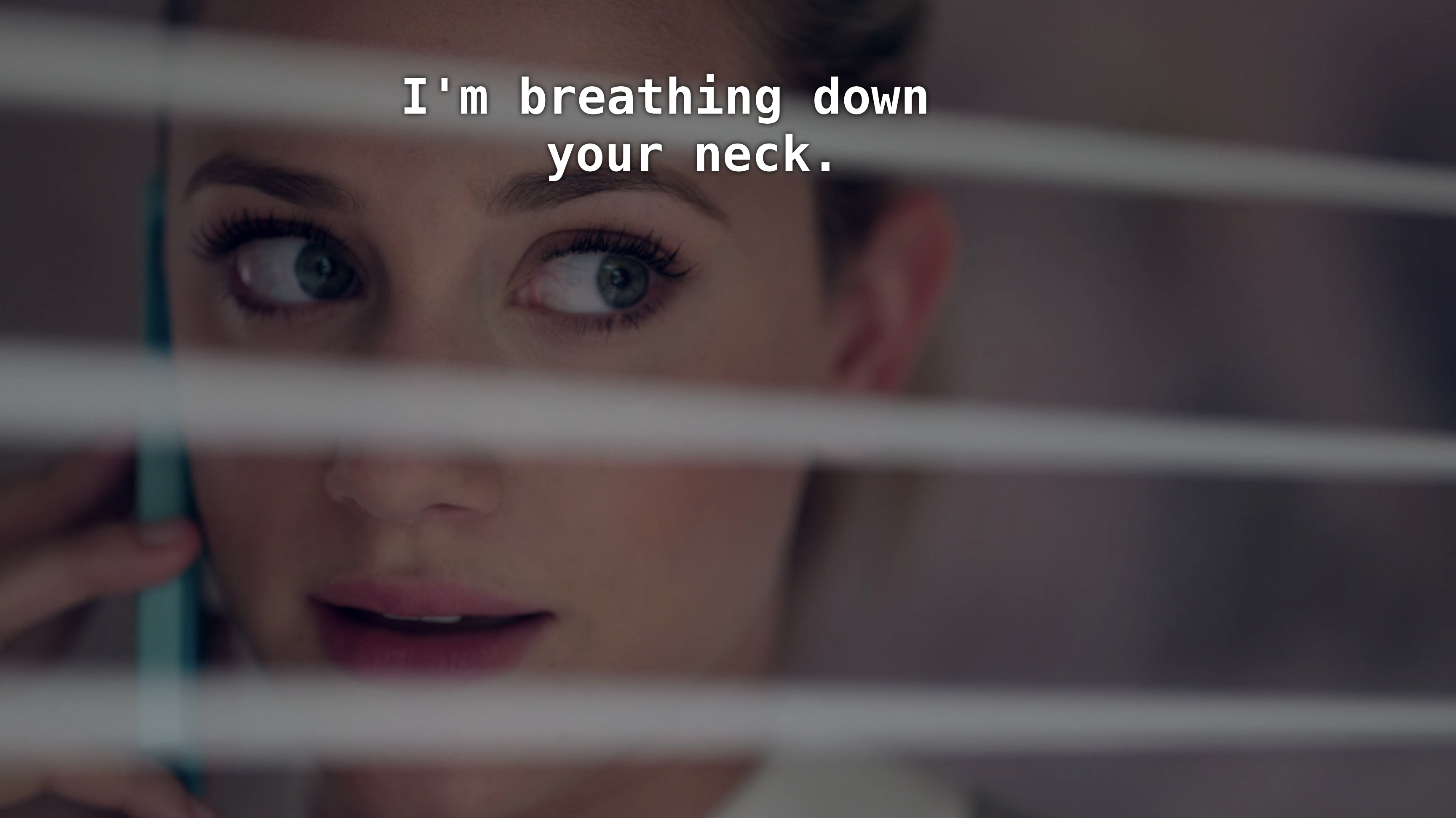 Close up of Betty looking through window shades. Betty: I'm breathing down your neck.