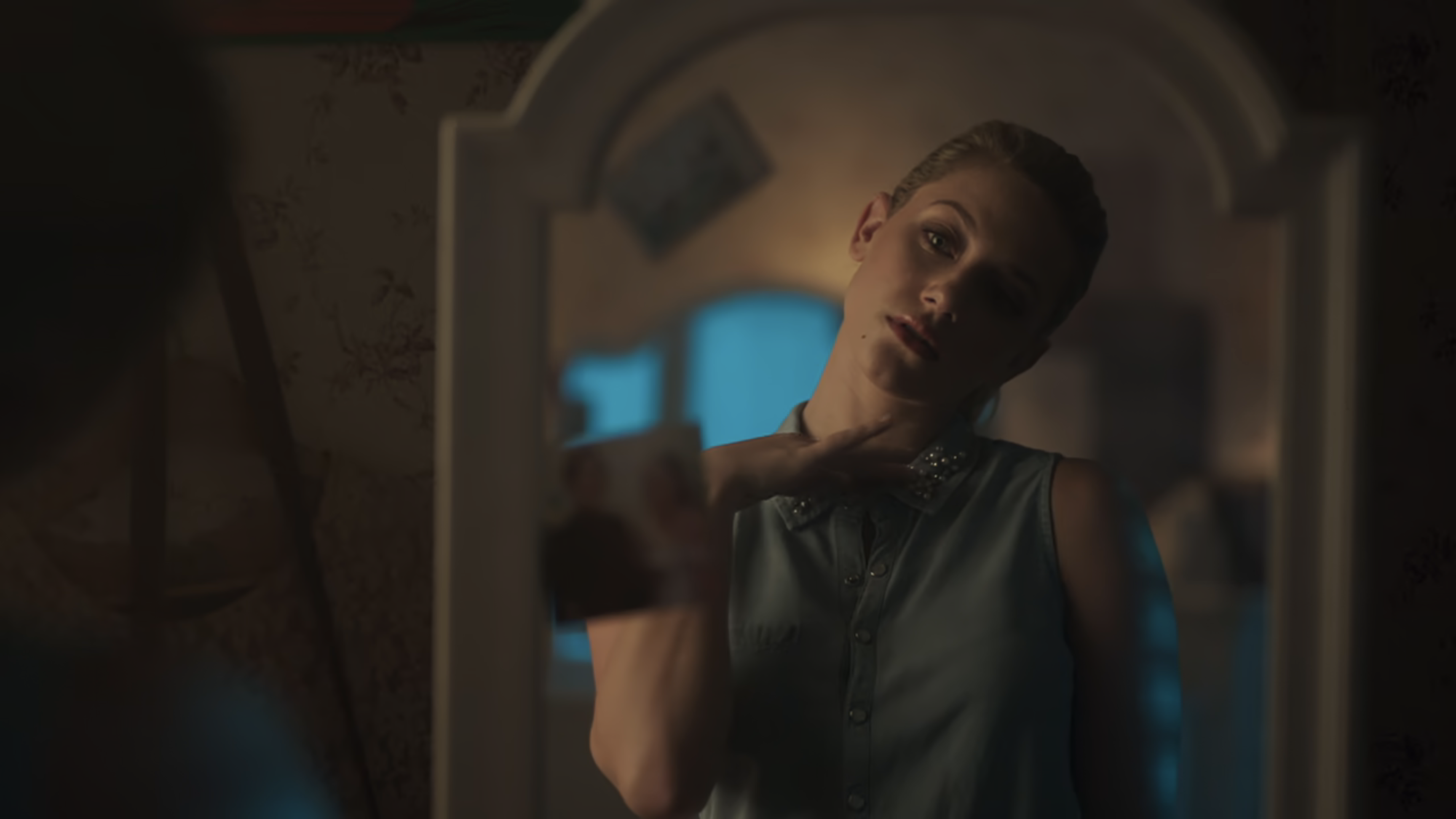 Betty looks at herself in the mirror.