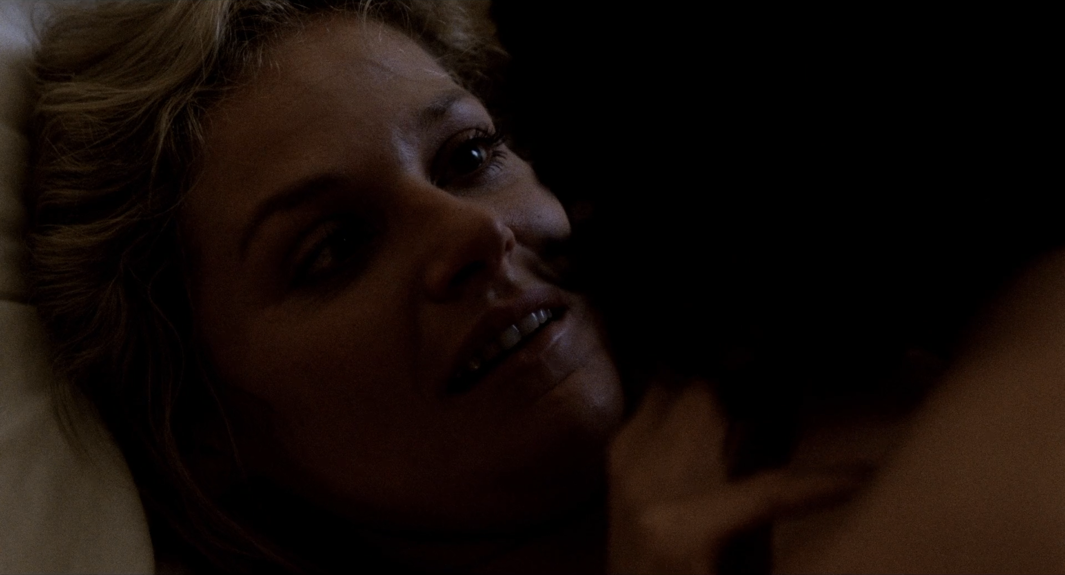 Vivian smiles as Cay looks at her while on top of her