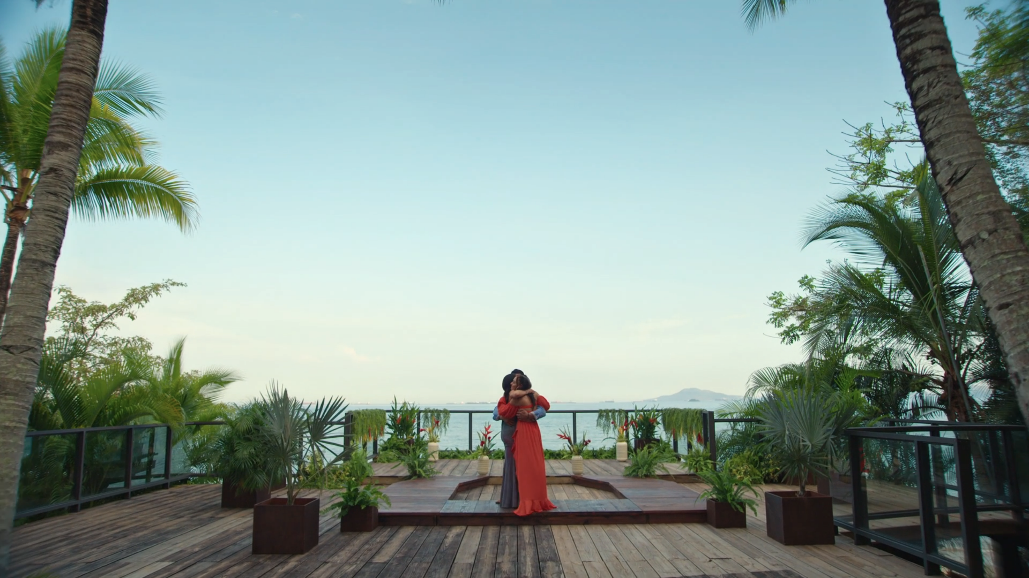 Lauren, Dylan, and Jess embrace on the tropical ceremony platform