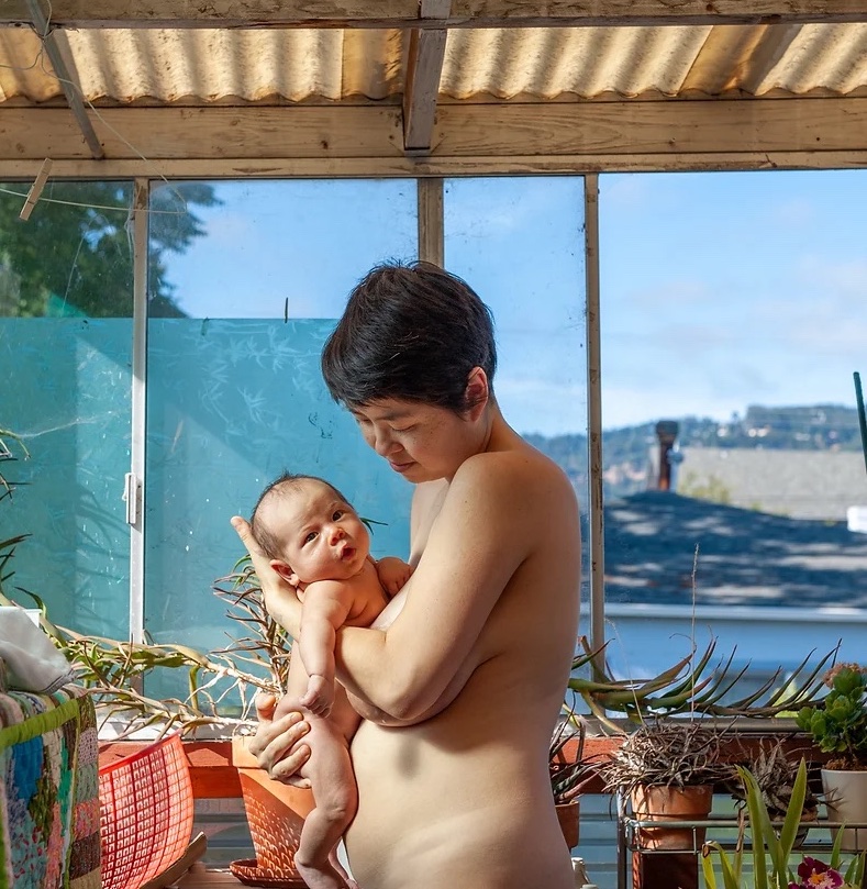 a queer mom holds a baby