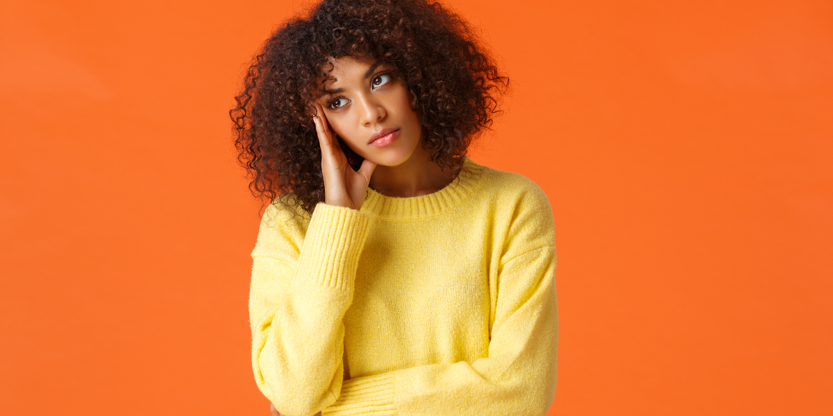 a woman in a yellow sweater looks bored