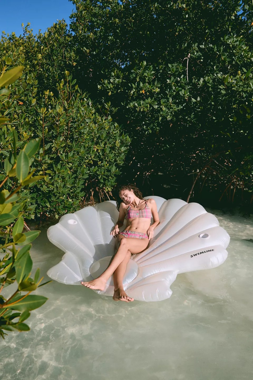 a woman in a seashell pool float