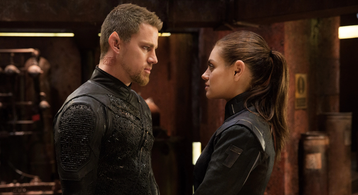 Channing Tatum and Mila Kunis look at each other.