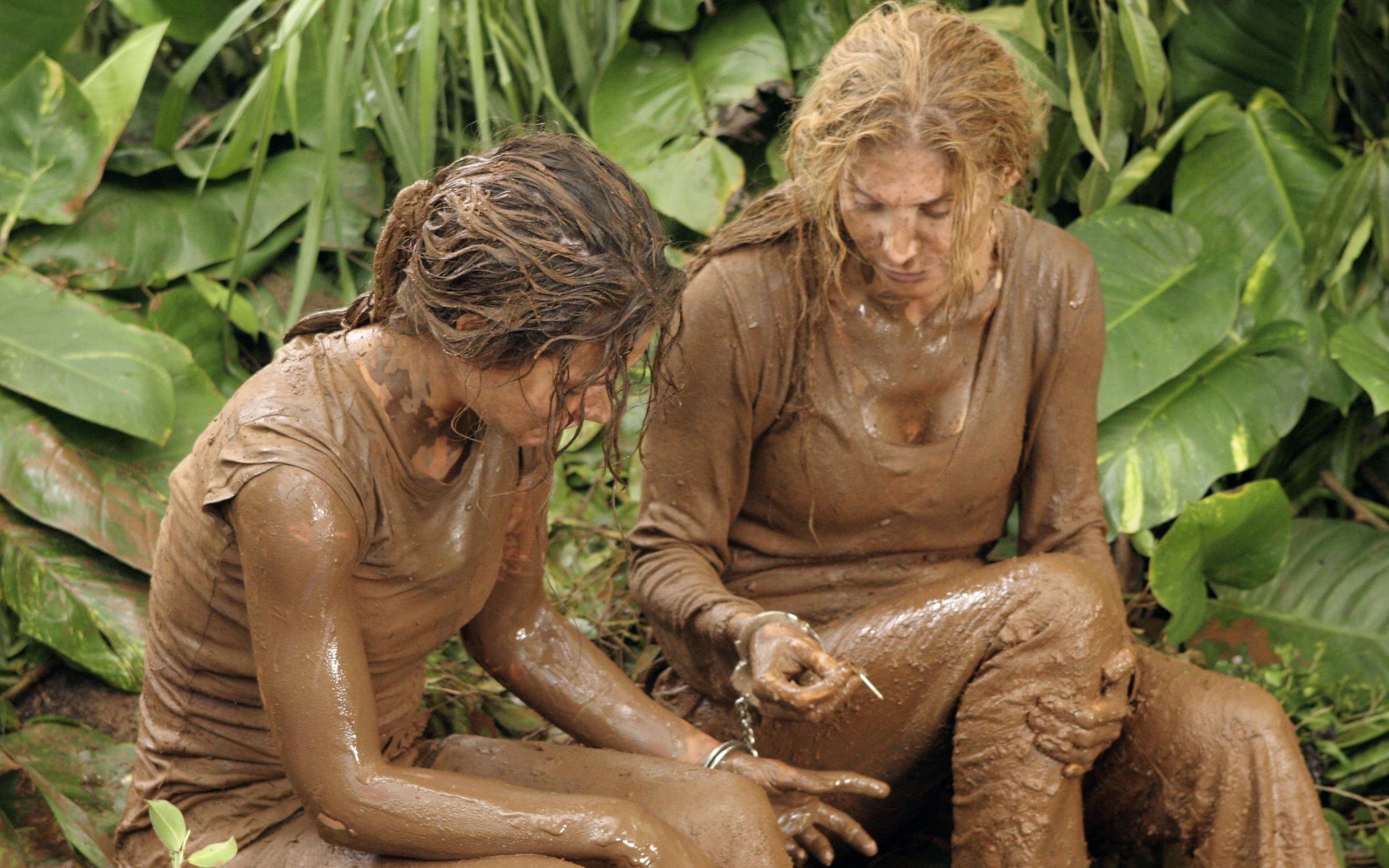 Kate and Juliet covered in mud handcuffed together.