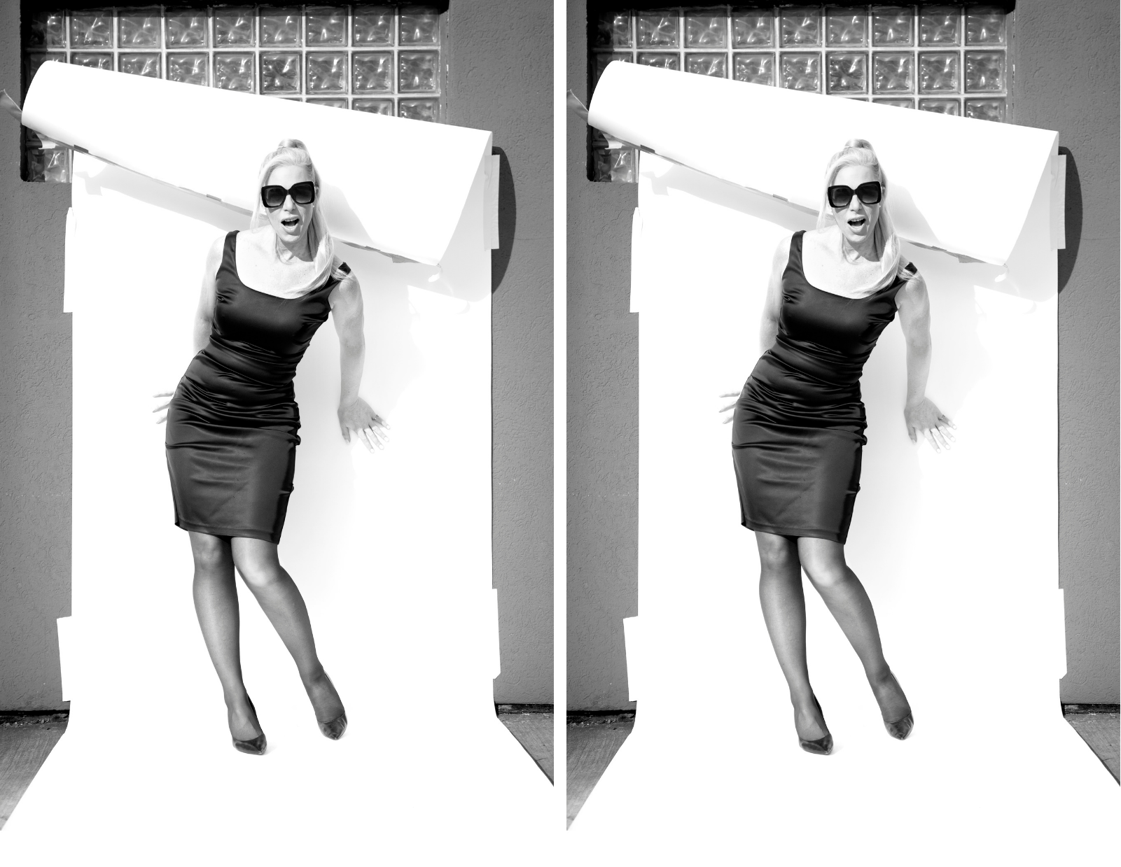 A black and white photo of Lisa Stephen Friday in a black sleeveless dress, tights, and heels, with black sunglasses, leaning against a white backdrop