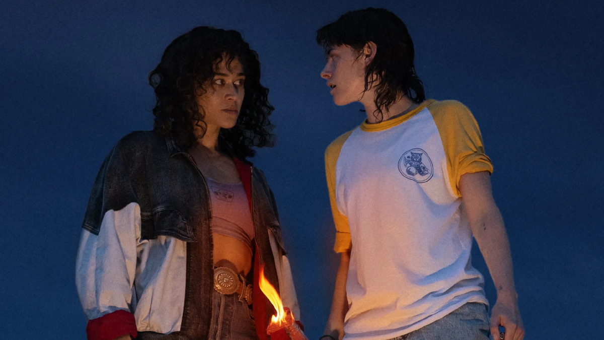 Kristen Stewart looks at Katy O'Brian before throwing a burning bottle.