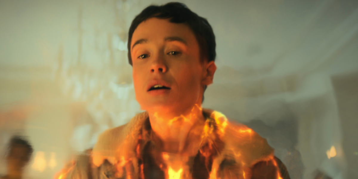 elliot page with fire coming up around him in the umbrella acdemy