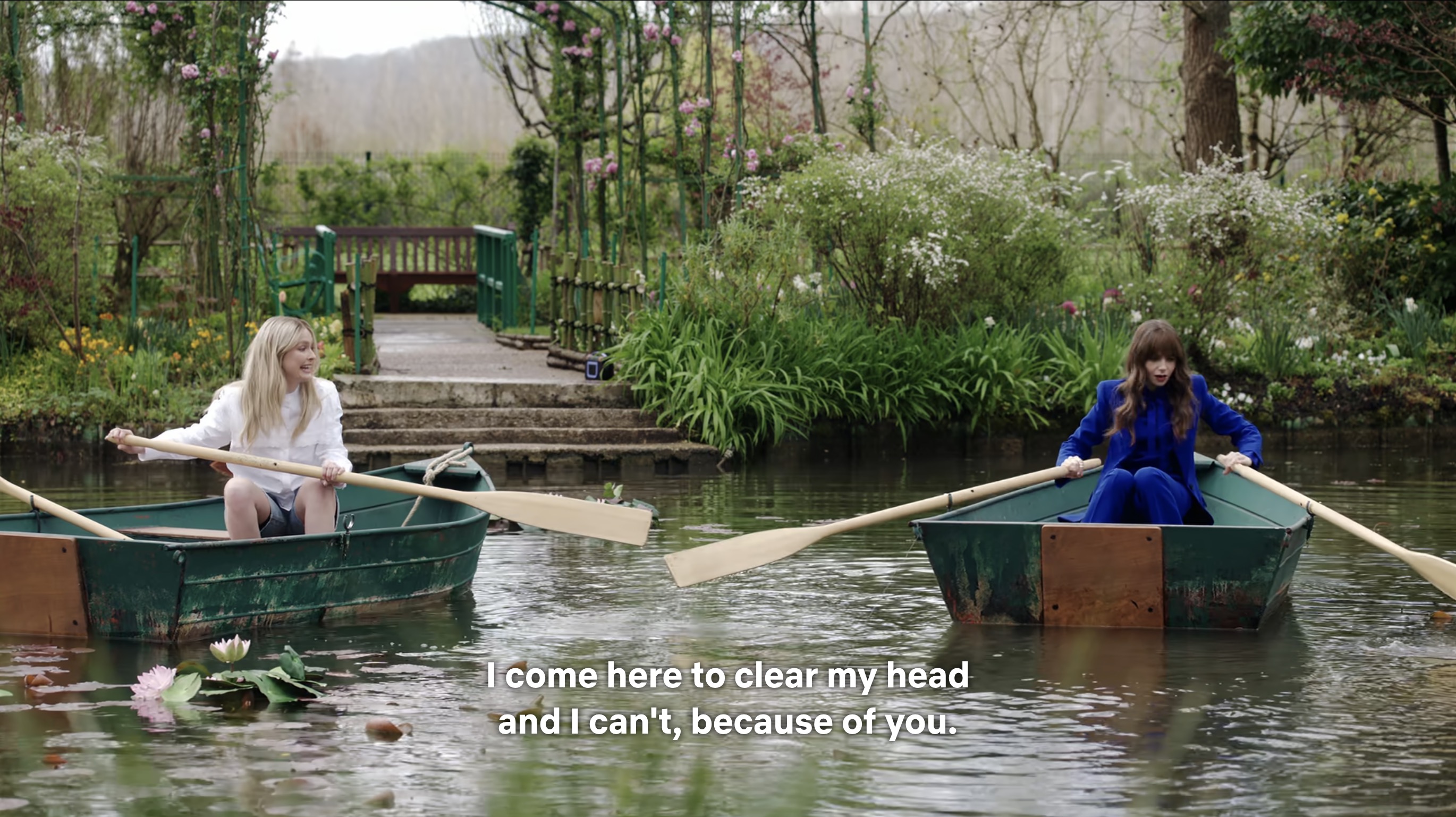 Camille shoving Emily's rowboat with her oar