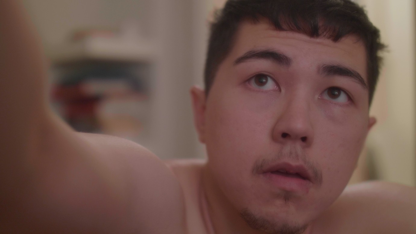 A close up on a trans guy's face.