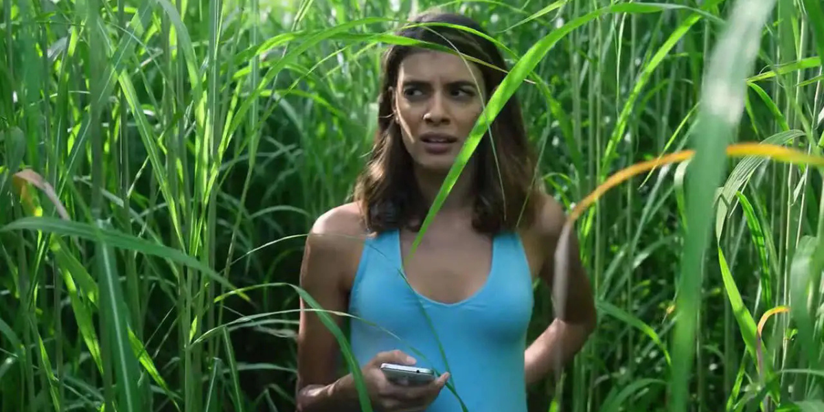 a woman walks in tall grass in In the Tall Grass