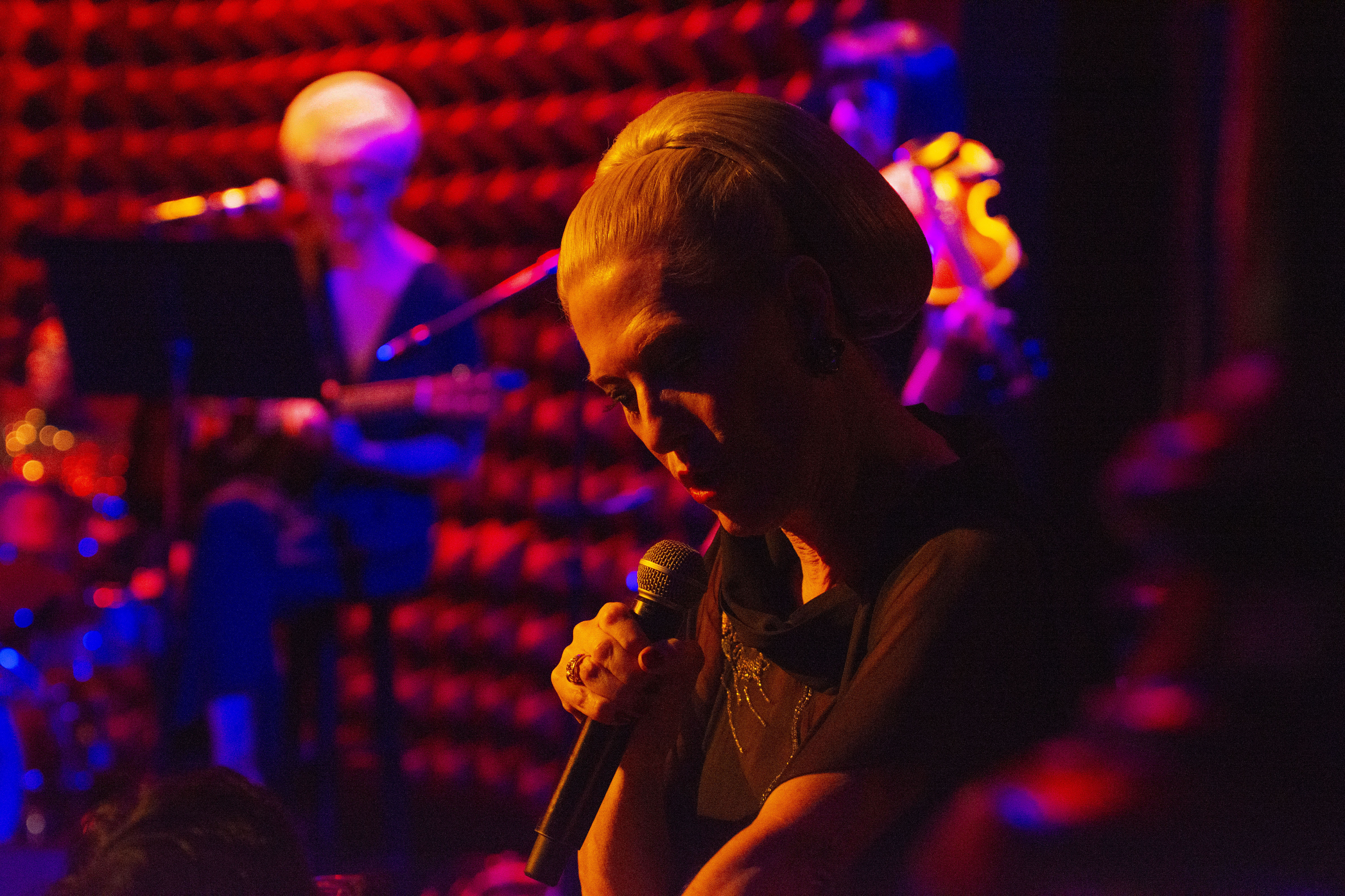 Justin Vivian Bond sings on stage awash in red light