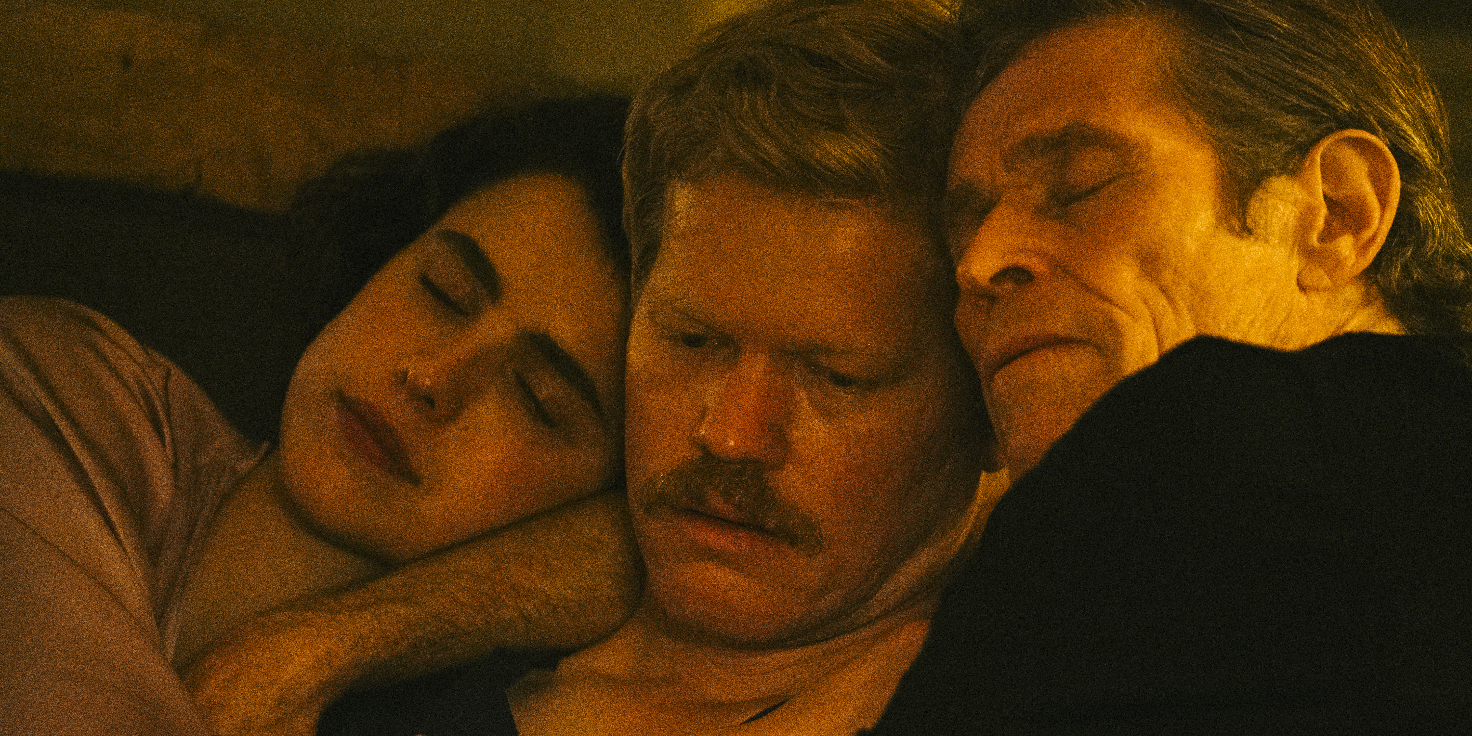 Jesse Plemons looks distraught as he is cuddled by Willem Dafoe and Margaret Qualley