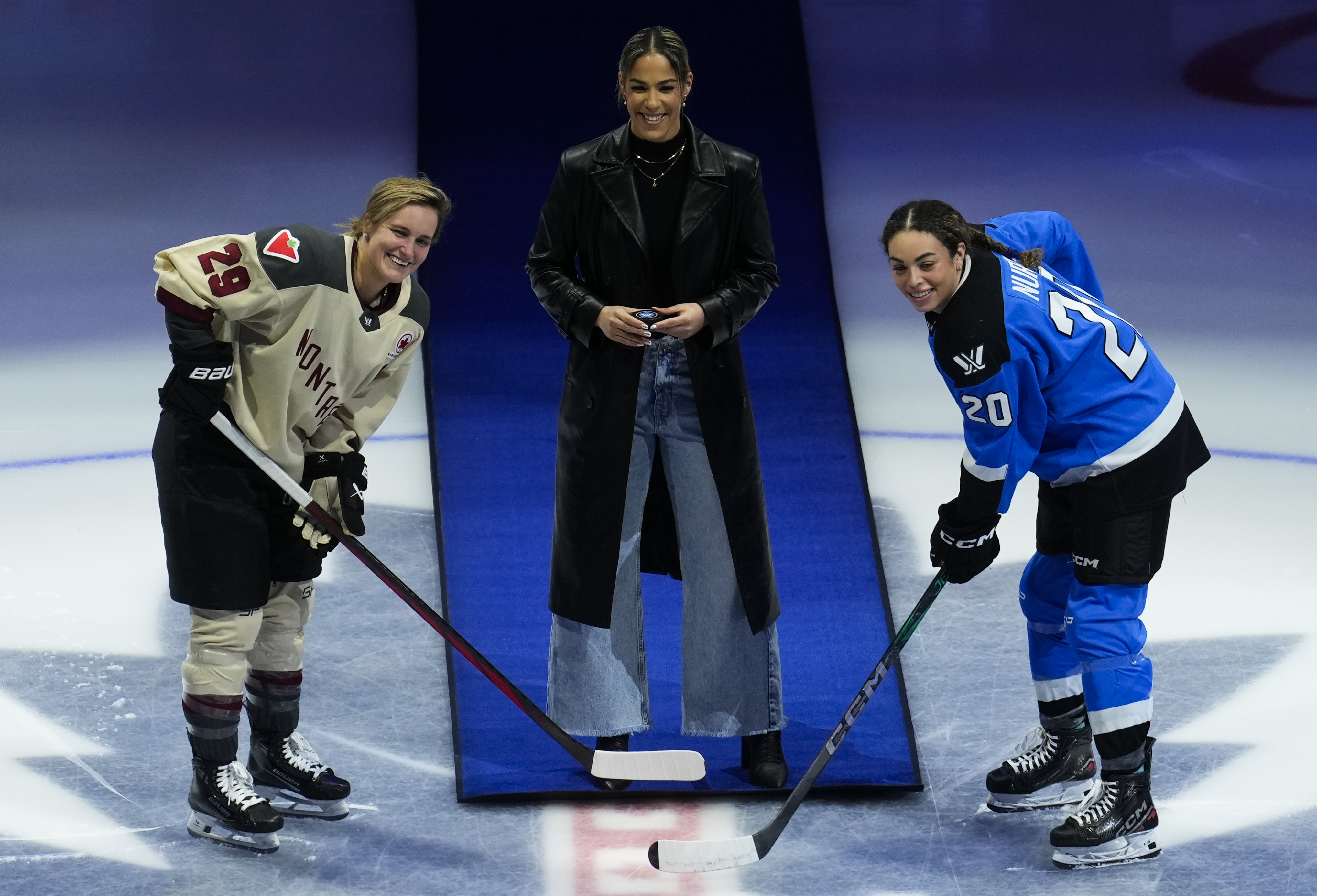 TORONTO, CANADA - FEBRUARY 16: WNBA player Kia Nurse (C) of the Los Angeles Sparks takes part in the ceremonial puck drop with Marie-Philip Poulin #29 of Montreal and Sarah Nurse #20 of Toronto before their PWHL hockey game at Scotiabank Arena on February 16, 2024 in Toronto, Canada. (Photo by Mark Blinch/Getty Images)