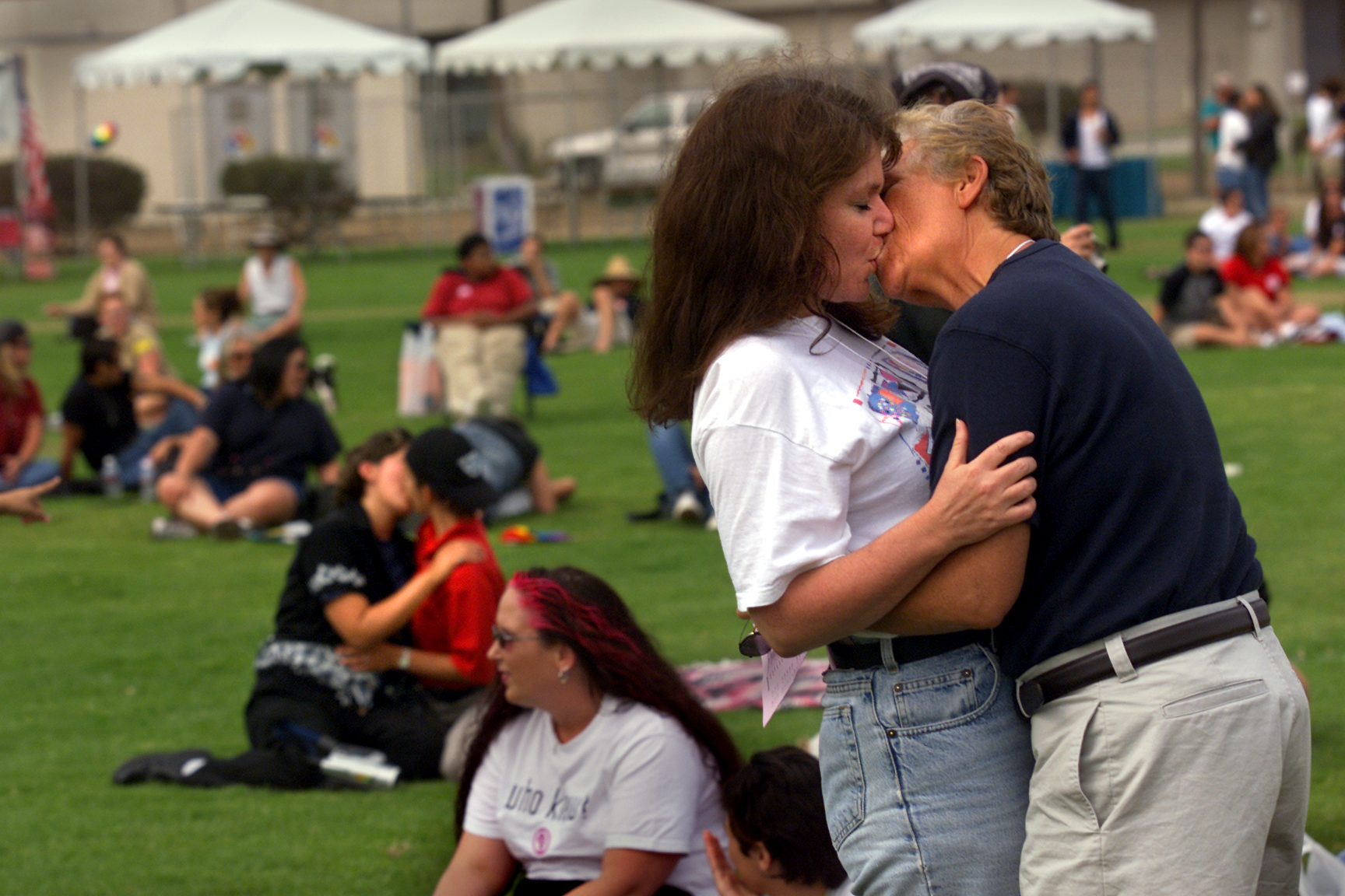 Denise Penn, left in foreground, an advocacy journalist for lesbian news, of San Clemente, kisses Jean Harris, field director for Dean For America (Governor candidate Howard Dean), Saturday during a kissIn at Orange County's first Dyke March at Lions Park in Costa Mesa. The parade aimed to promote social change, celebrate women and fight discrimination, antigay violence and harassment. The event, which began at Lions Park, included live entertainment and women's health information. The march was sponsored by the Gay and Lesbian Community Center. (Photo by Al Schaben/Los Angeles Times via Getty Images)