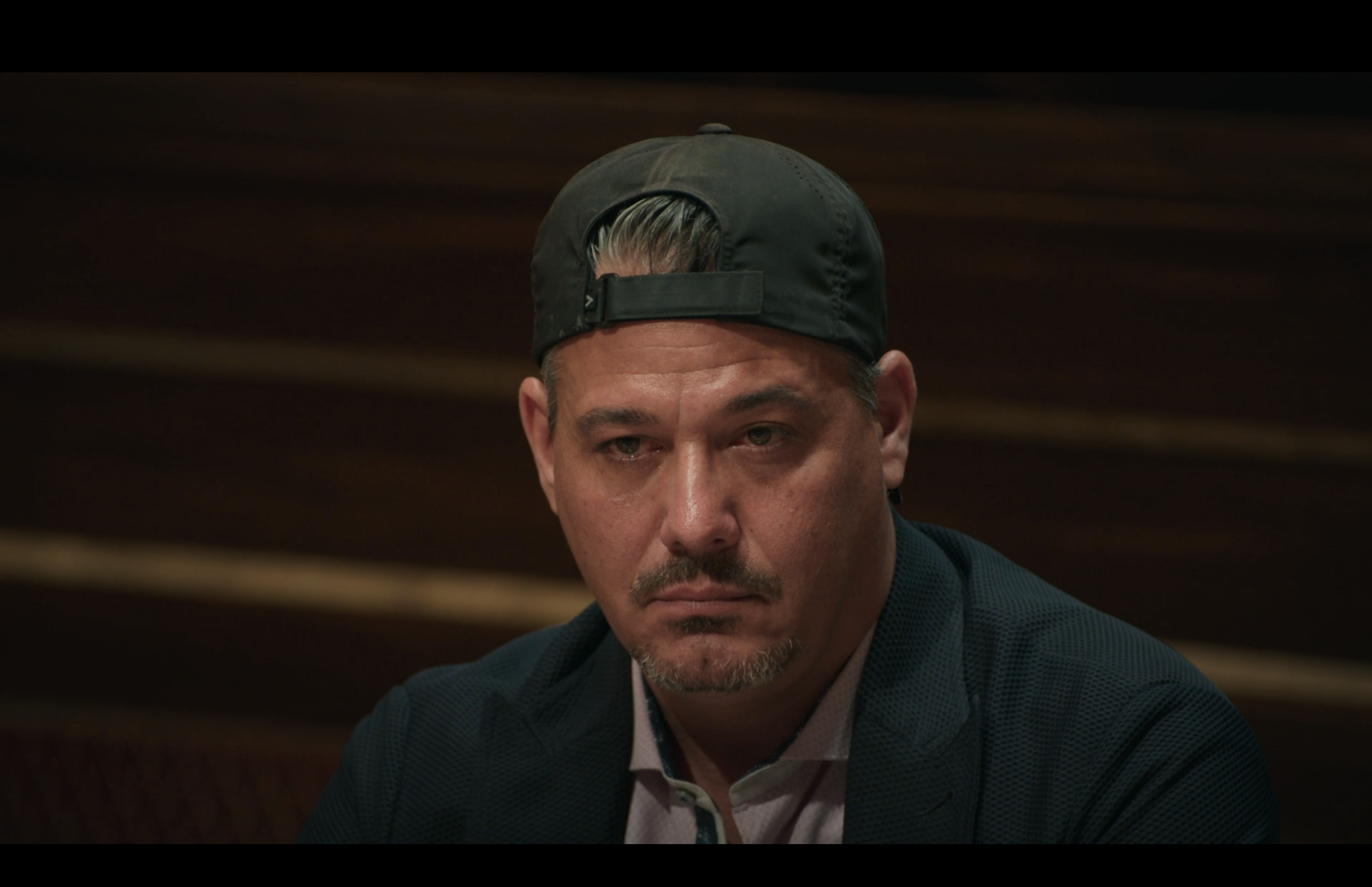 Boston Rob in a backwards hat scowling like a pathetic loser.