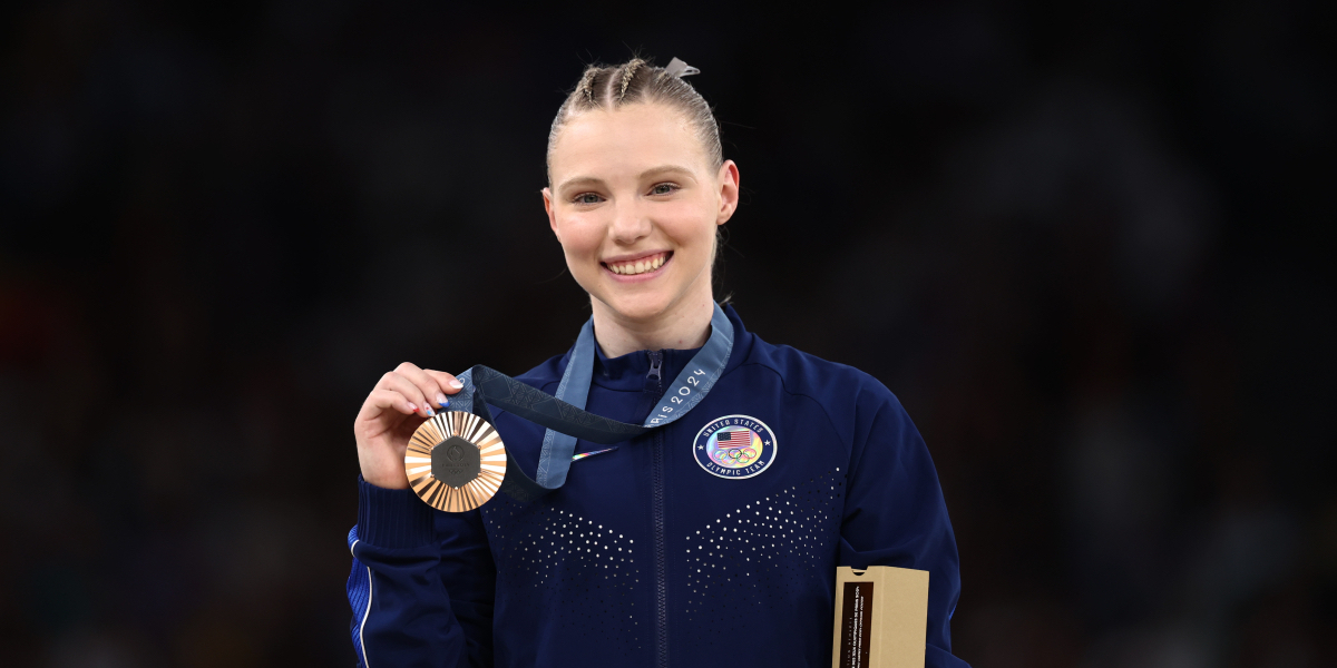 Jade Carey who came out and has a girlfriend holds up a bronze medal for a photo