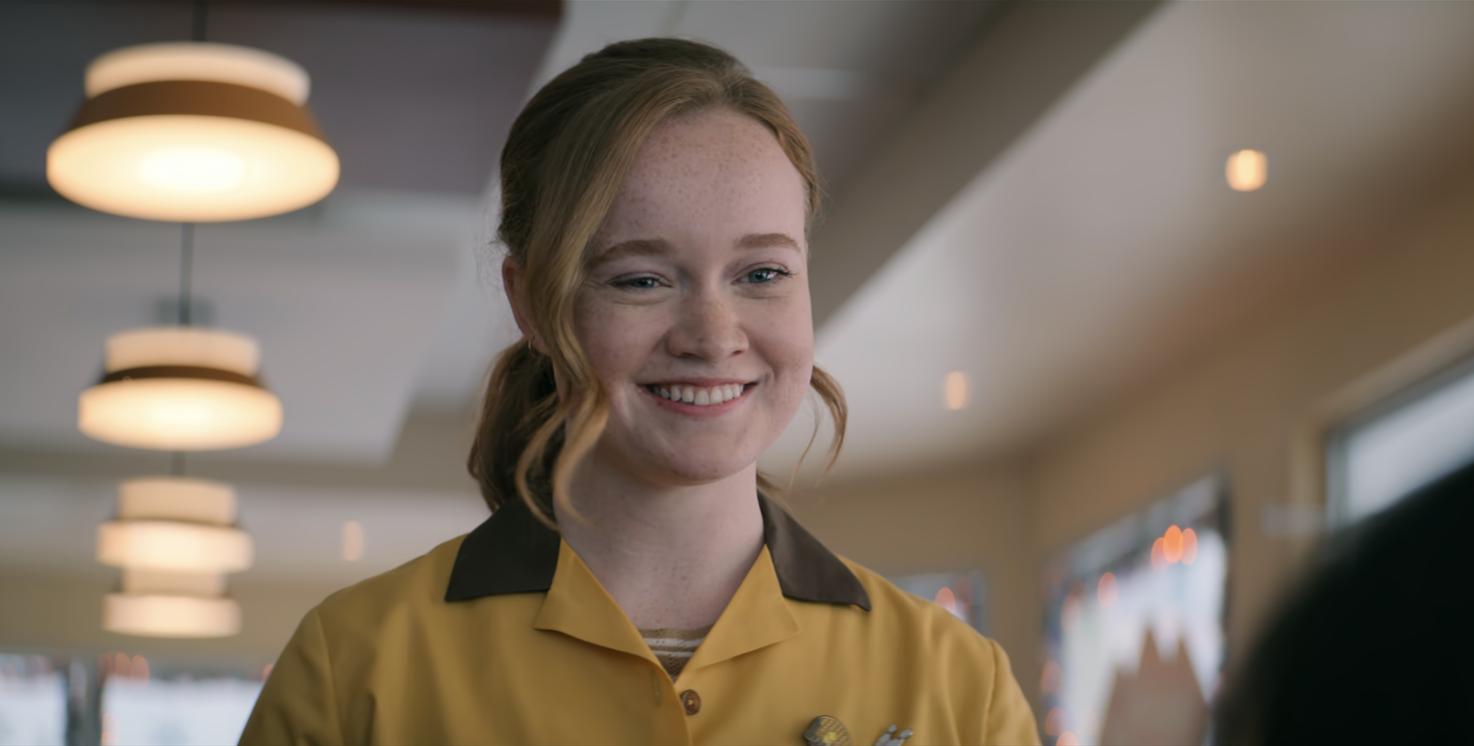 Liv Hewson smiles in a diner uniform