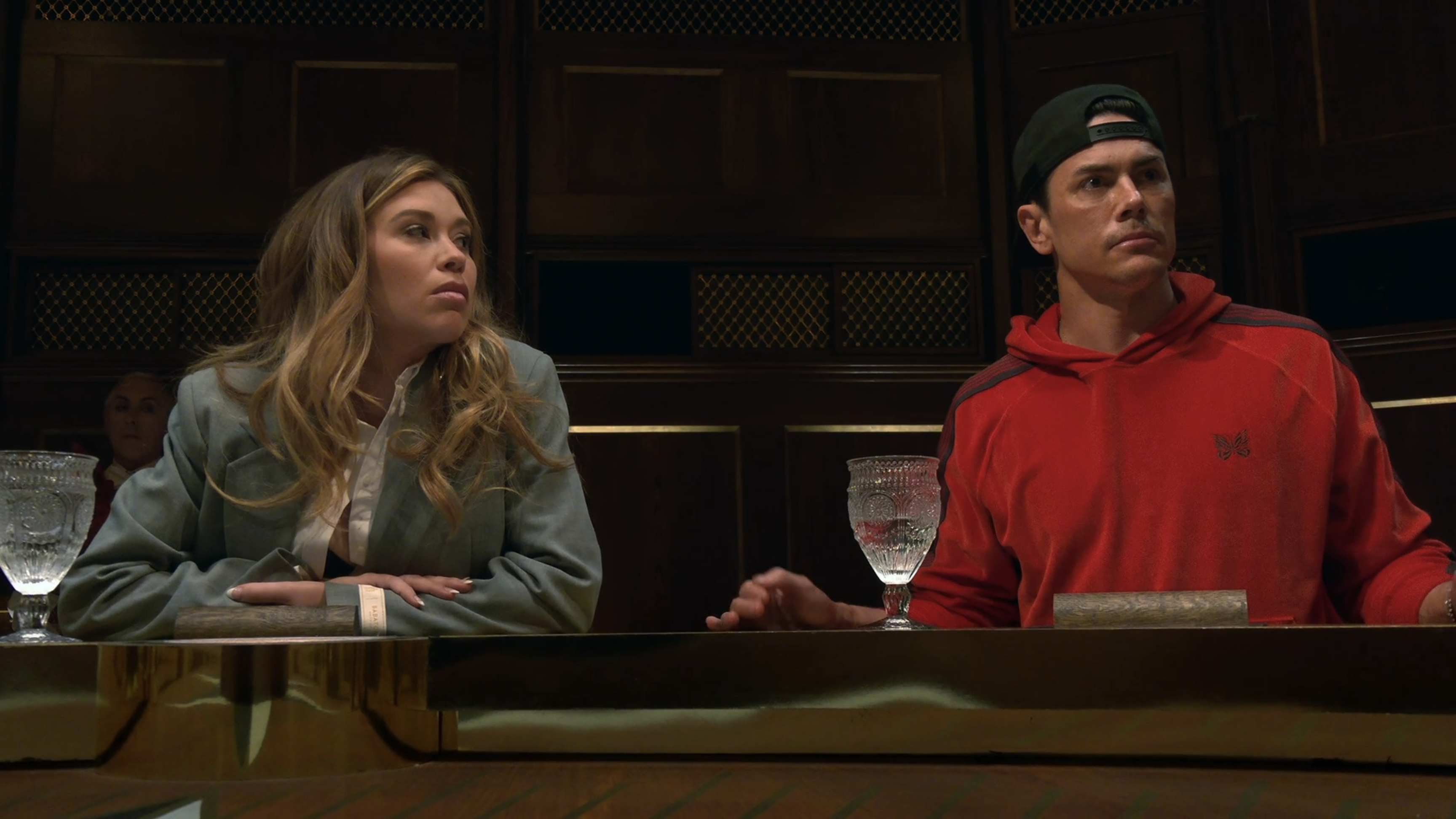 Gabby in a boxy suit sits next to Tom Sandoval at the Traitors roundtable.