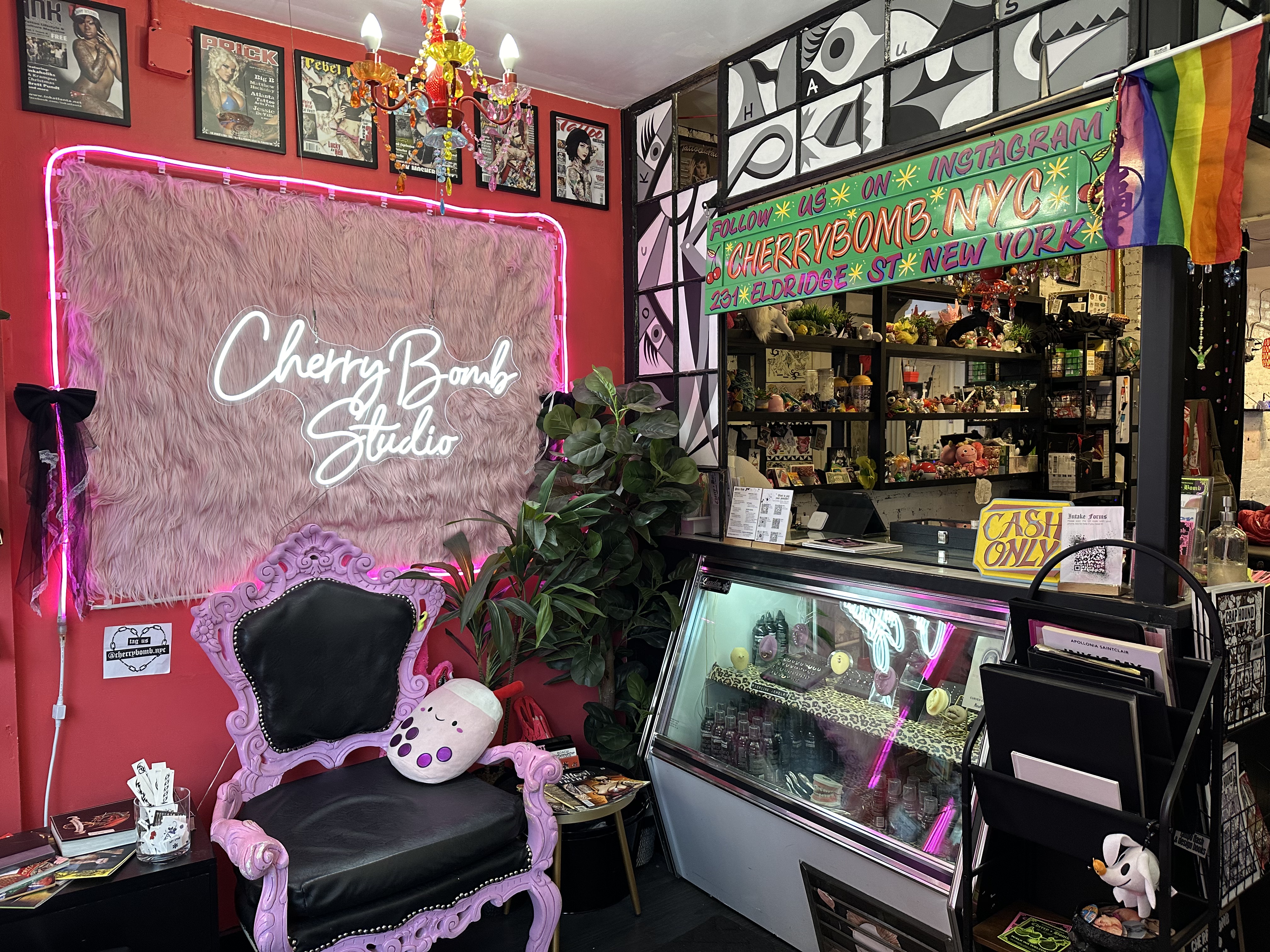 Cherry Bomb Studio's front desk with purples and pinks and a visible Pride flag.