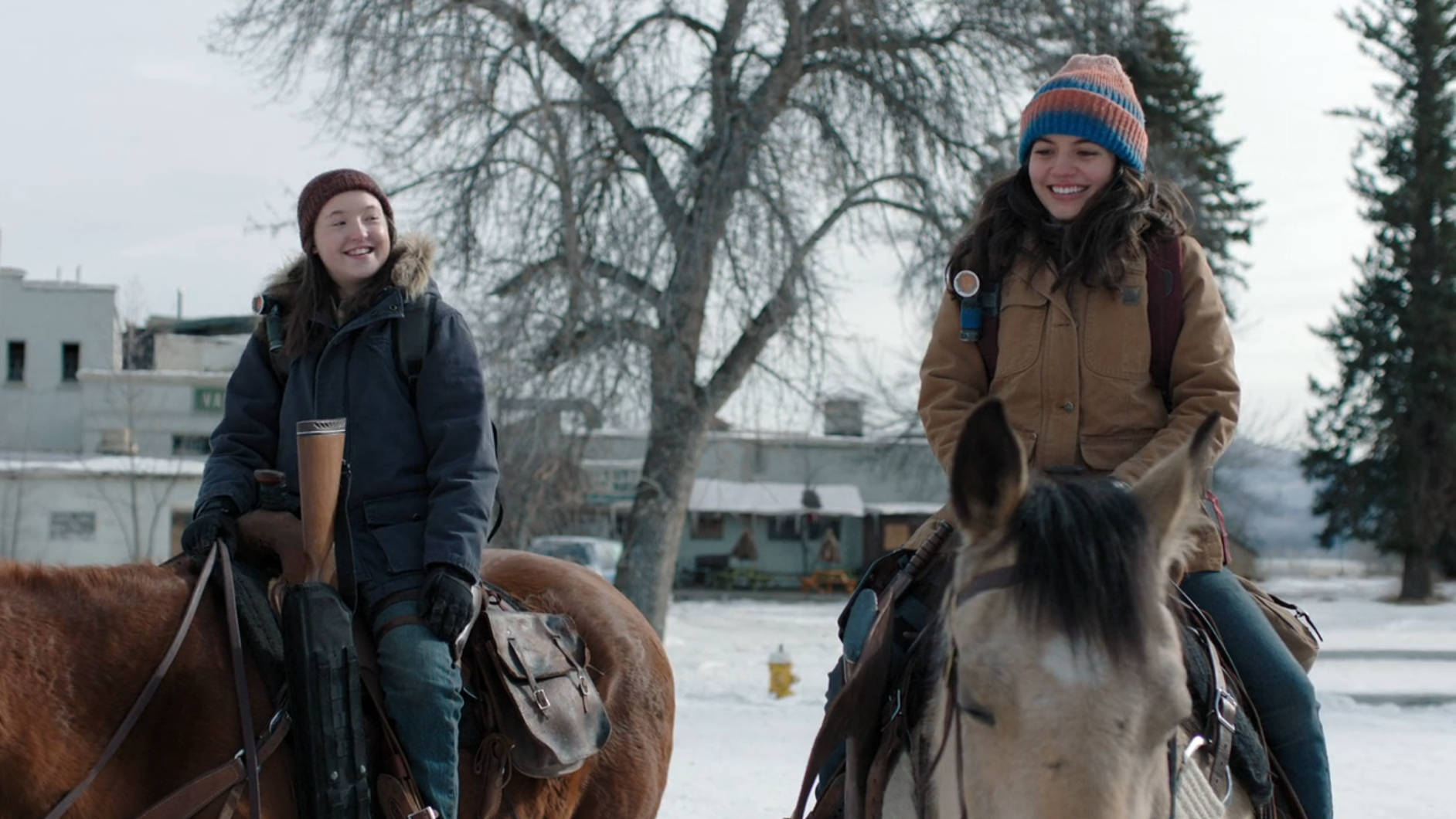 The Last of Us: Ellie and Dina sit on their horses smiling out on patrol