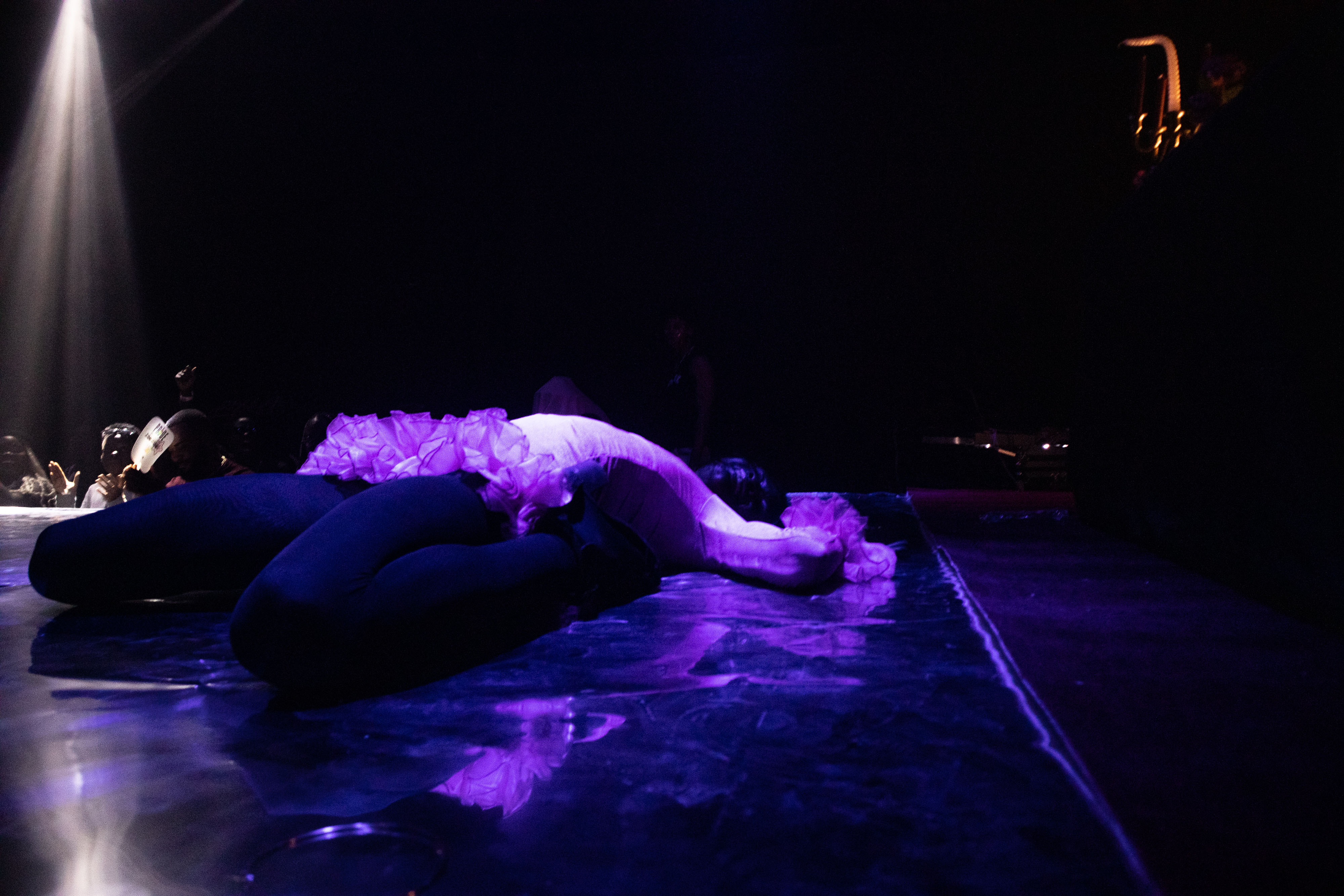 Heavenly Bodies a ballroom performer in a death drop, cast in purple light