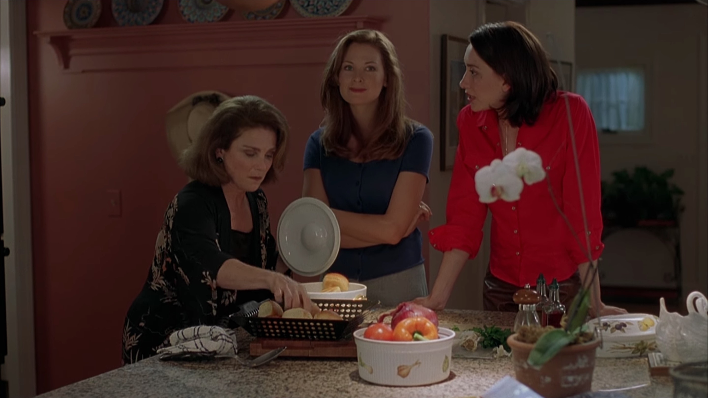 Jennifer Westfeldt stands with her arms crossed next to Heather Juergensen as Tovah Feldshuh serves food.