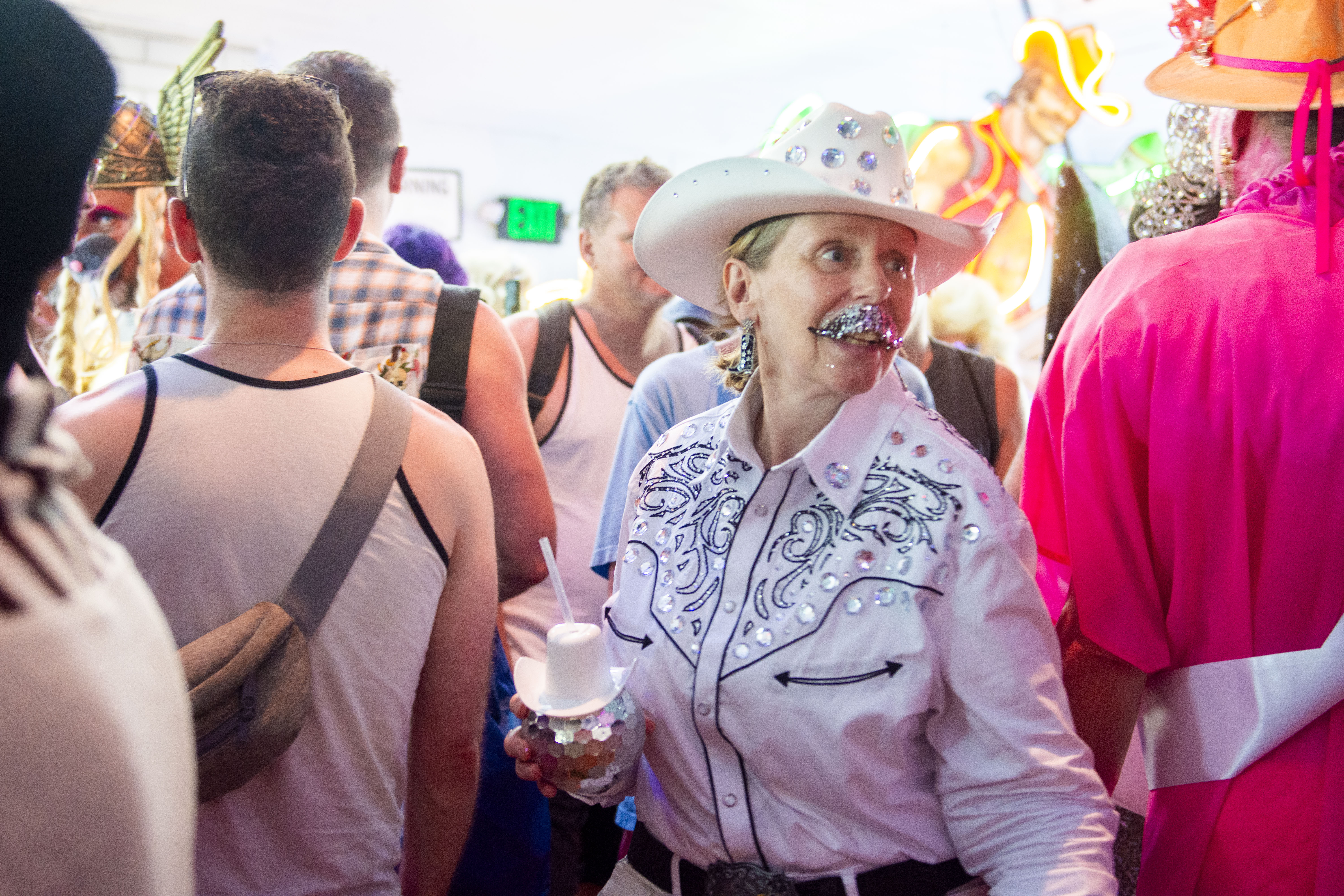 a queer person in a cowboy getup with gliterry moustach