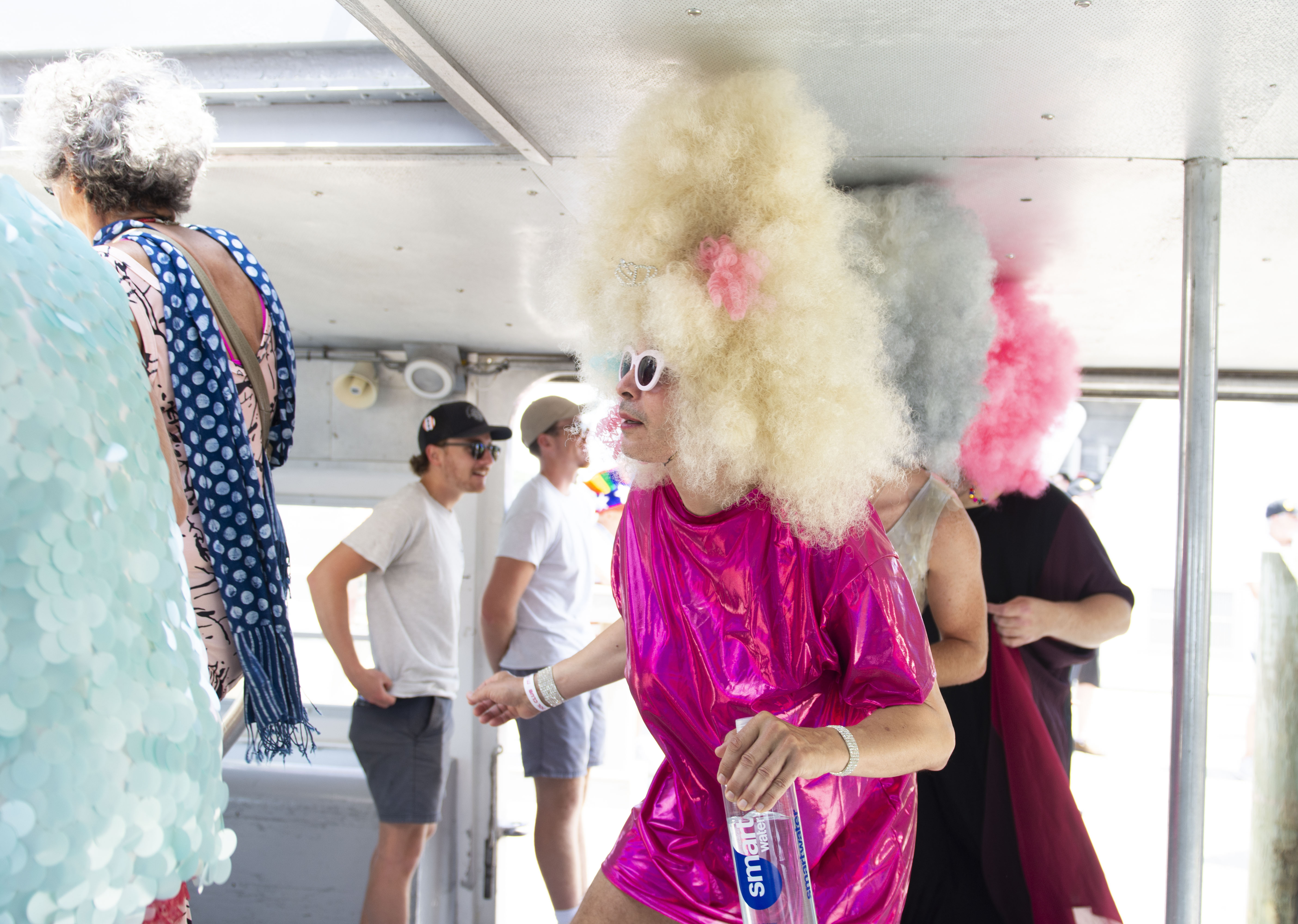 drag queens in giant wigs boarding a ferry